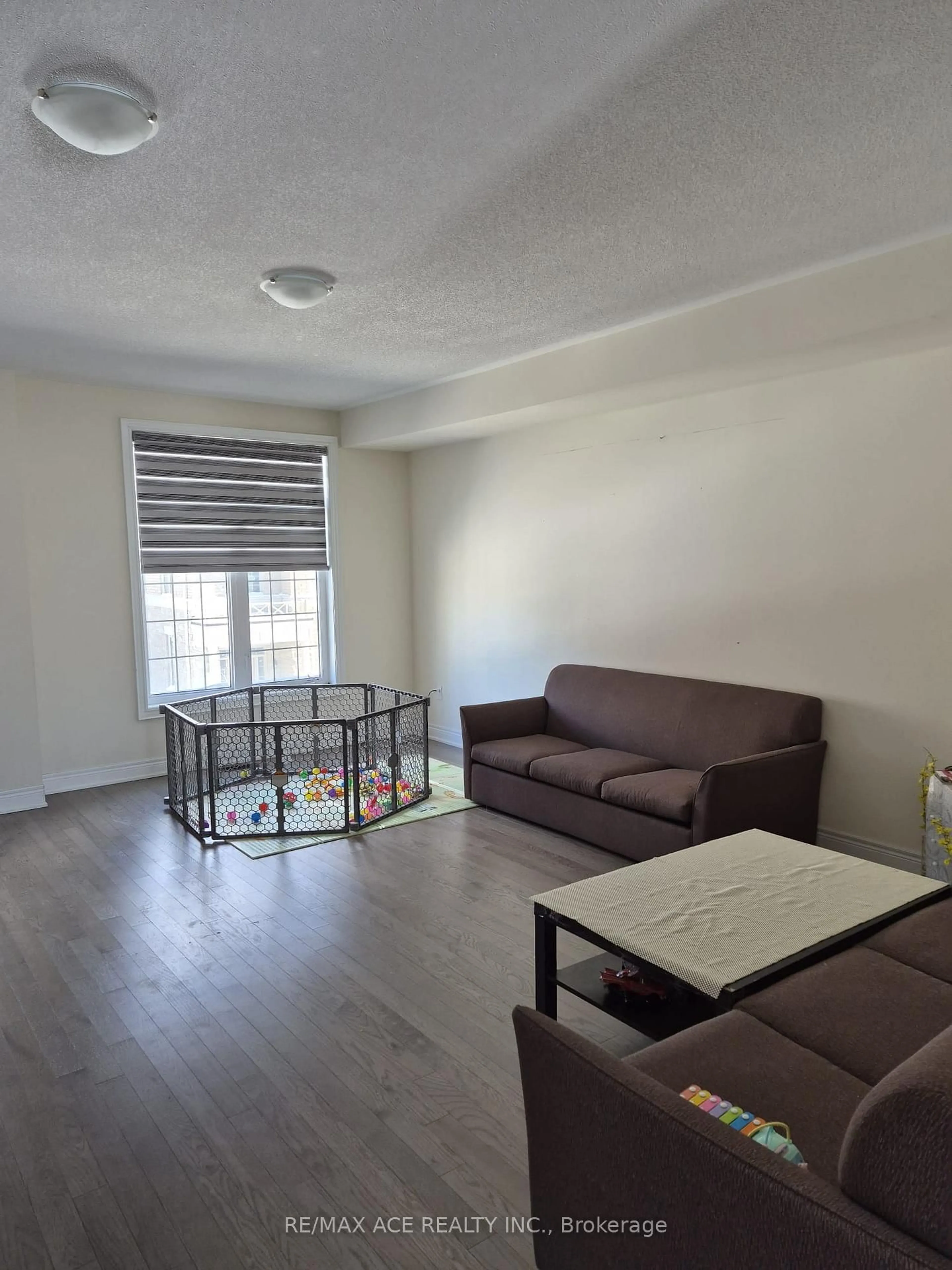 Living room with furniture, wood/laminate floor for 32 Andress Way, Markham Ontario L3S 0E9