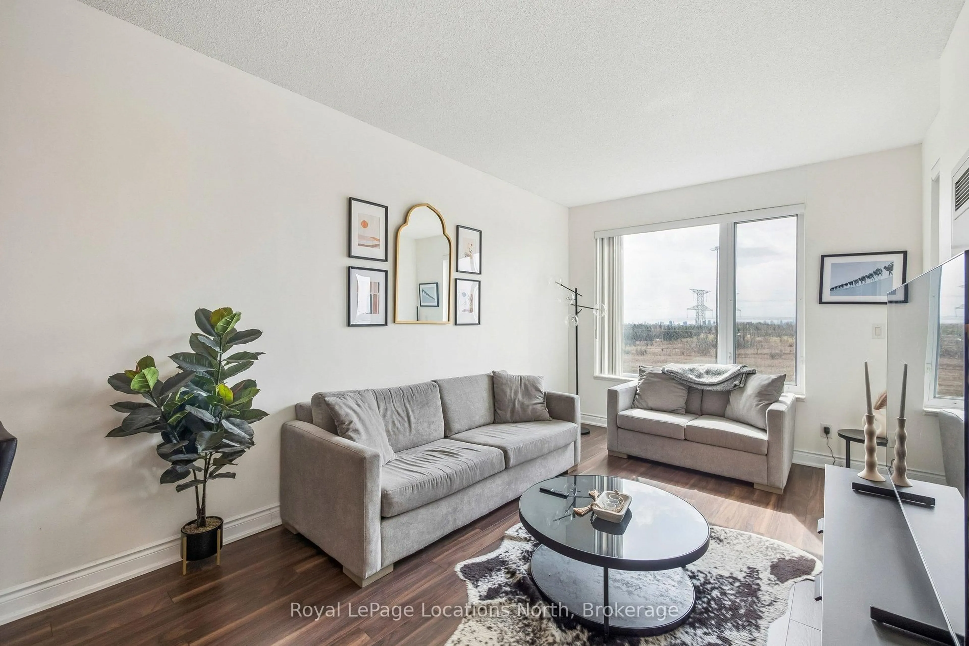 Living room with furniture, wood/laminate floor for 277 South Park Rd #810, Markham Ontario L3T 0B7