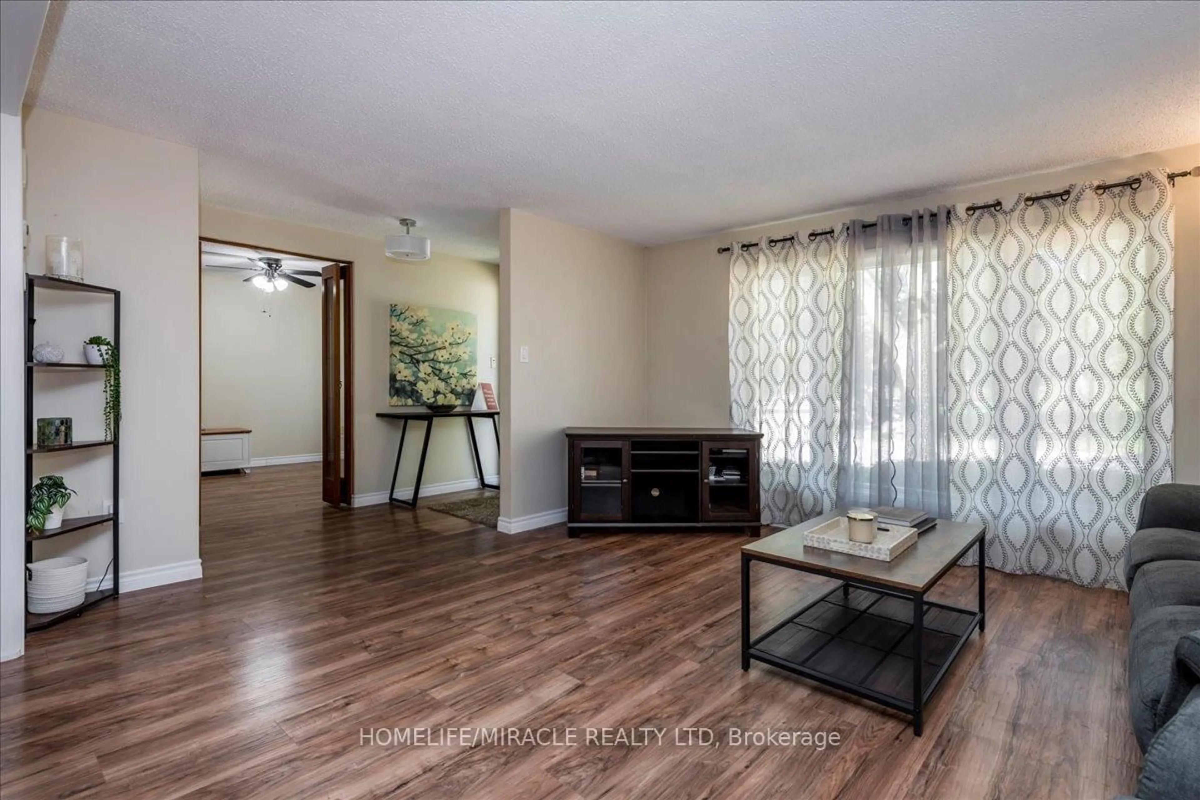 Living room with furniture, wood/laminate floor for 1 Tecumseth Pines Dr, New Tecumseth Ontario L0G 1W0