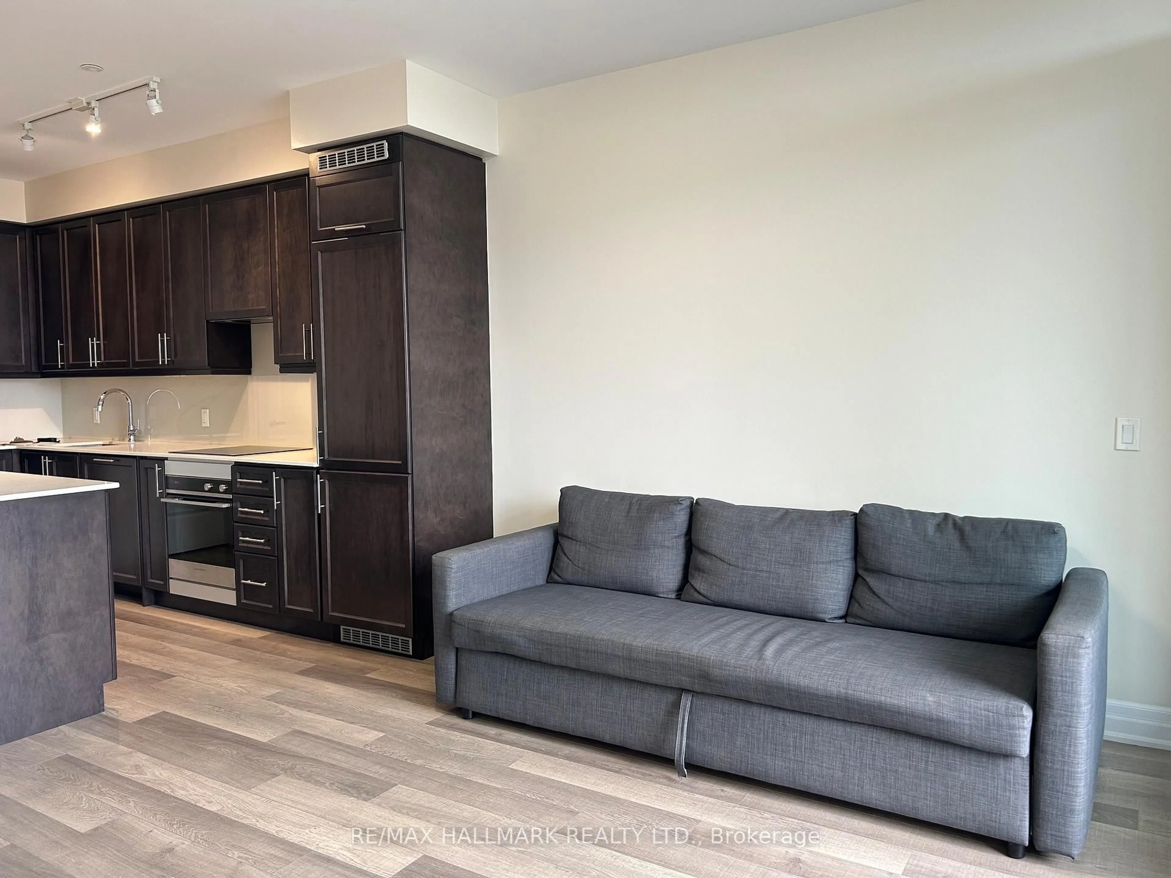 Living room with furniture, wood/laminate floor for 9085 Jane St #219, Vaughan Ontario L4K 0L8