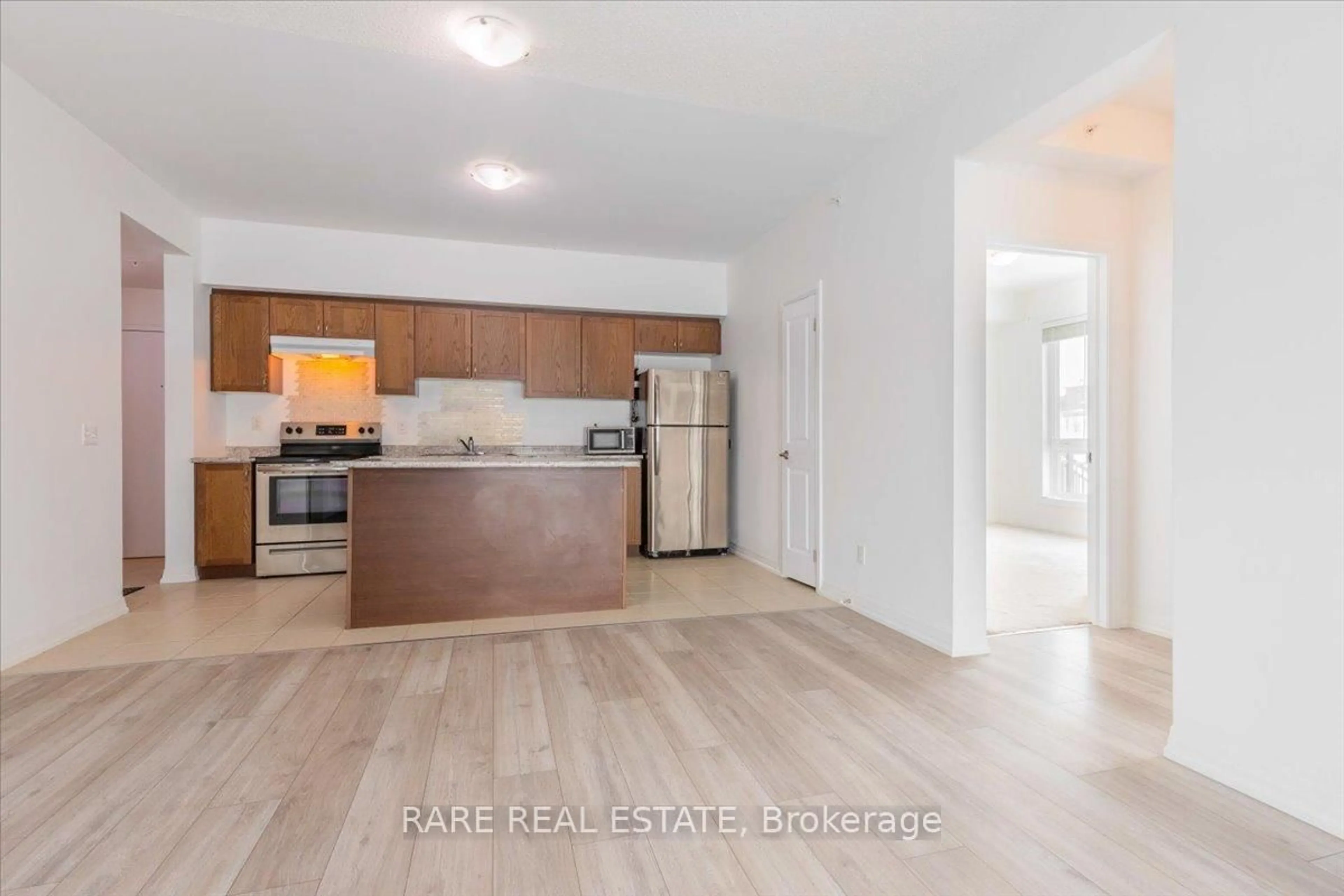 Open concept kitchen, wood/laminate floor for 299 Cundles Rd #102, Barrie Ontario L4M 0K9
