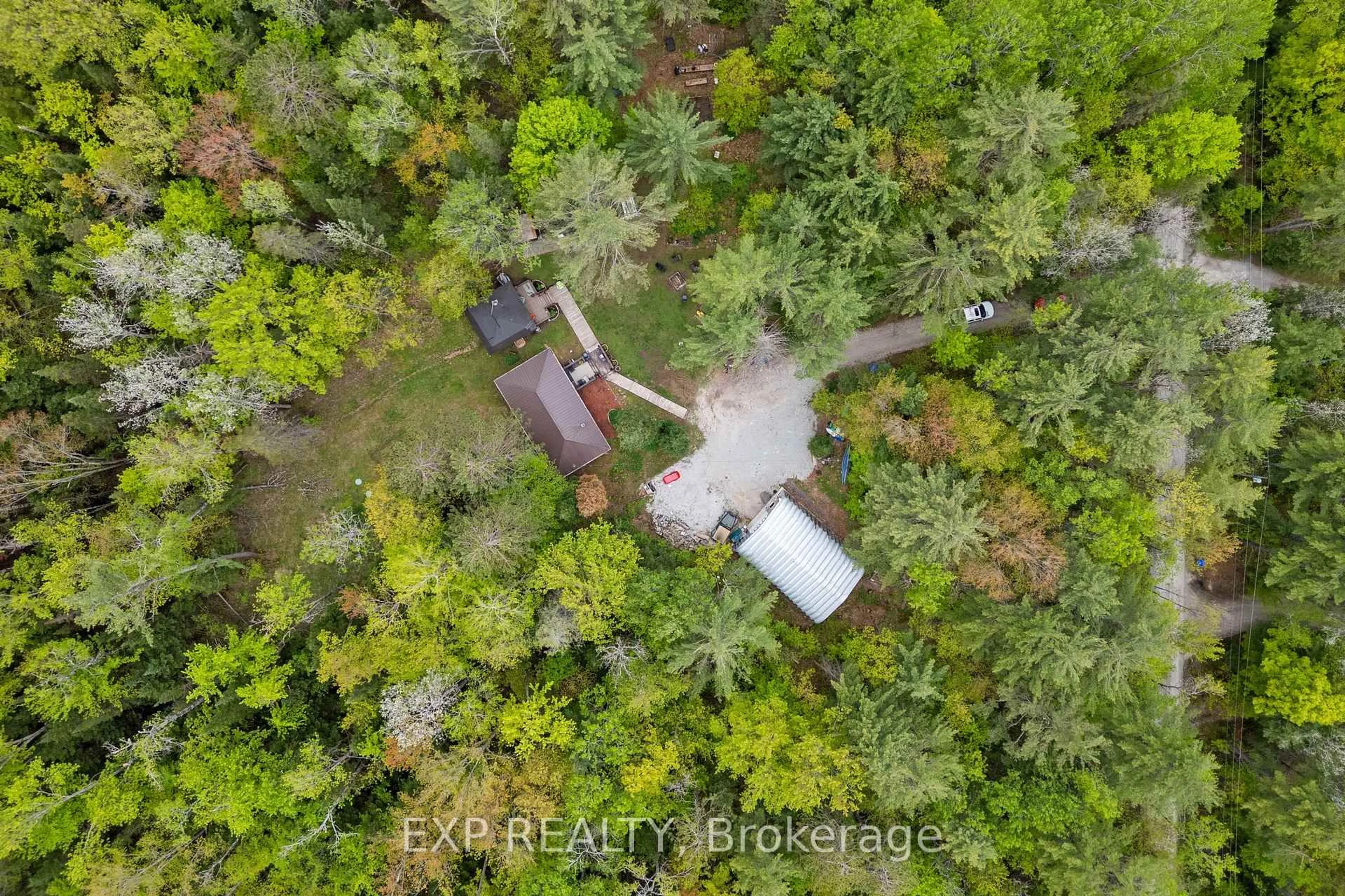 A pic from outside/outdoor area/front of a property/back of a property/a pic from drone, forest/trees view for 6566 Pioneer Village Lane, Ramara Ontario L0K 1W0