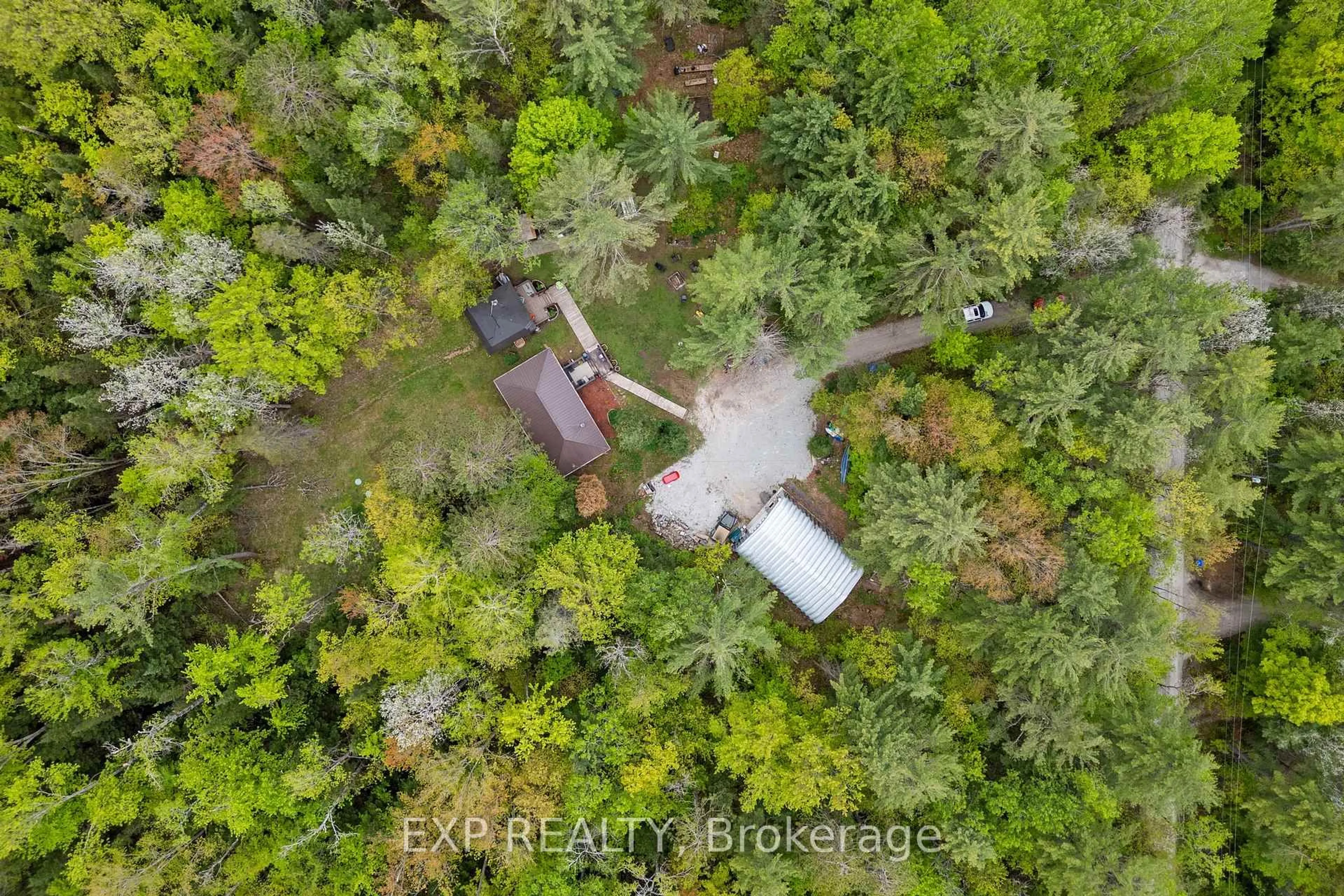 A pic from outside/outdoor area/front of a property/back of a property/a pic from drone, forest/trees view for 6566 Pioneer Village Lane, Ramara Ontario L0K 1W0
