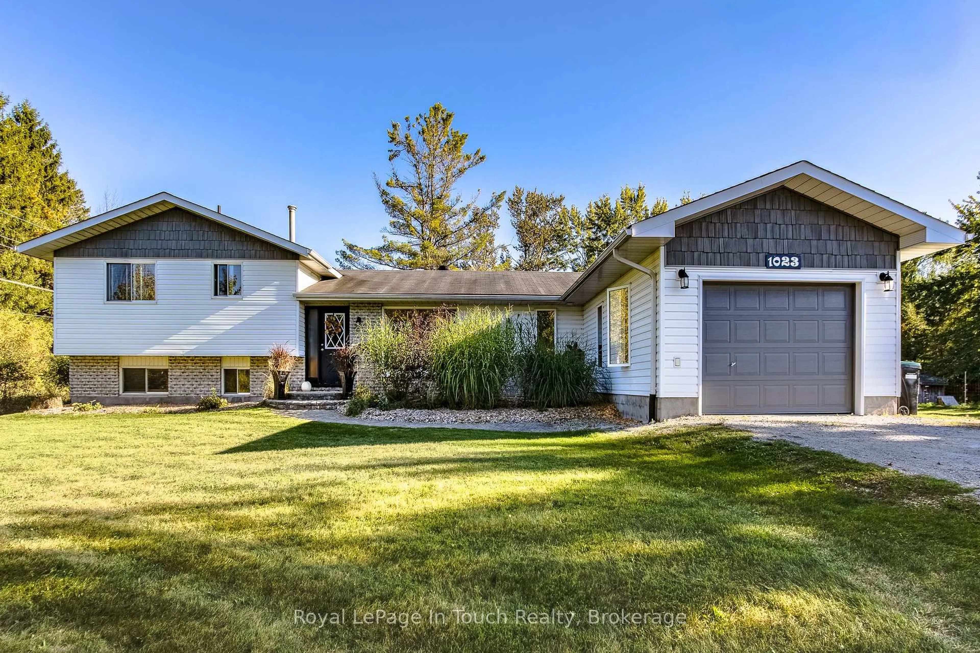 Home with vinyl exterior material, street for 1023 Flos 4 Rd, Springwater Ontario L0L 2K0