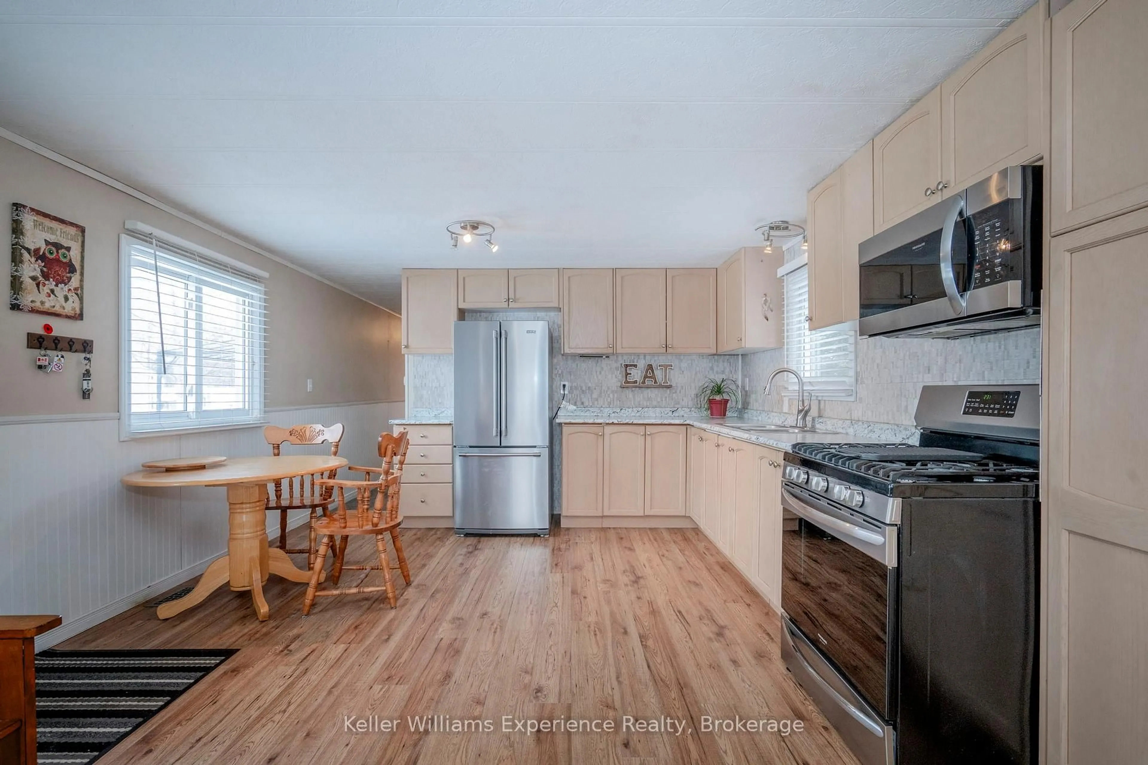 Open concept kitchen, wood/laminate floor for 5263 ELLIOTT Sdrd #46, Tay Ontario L4R 4K3