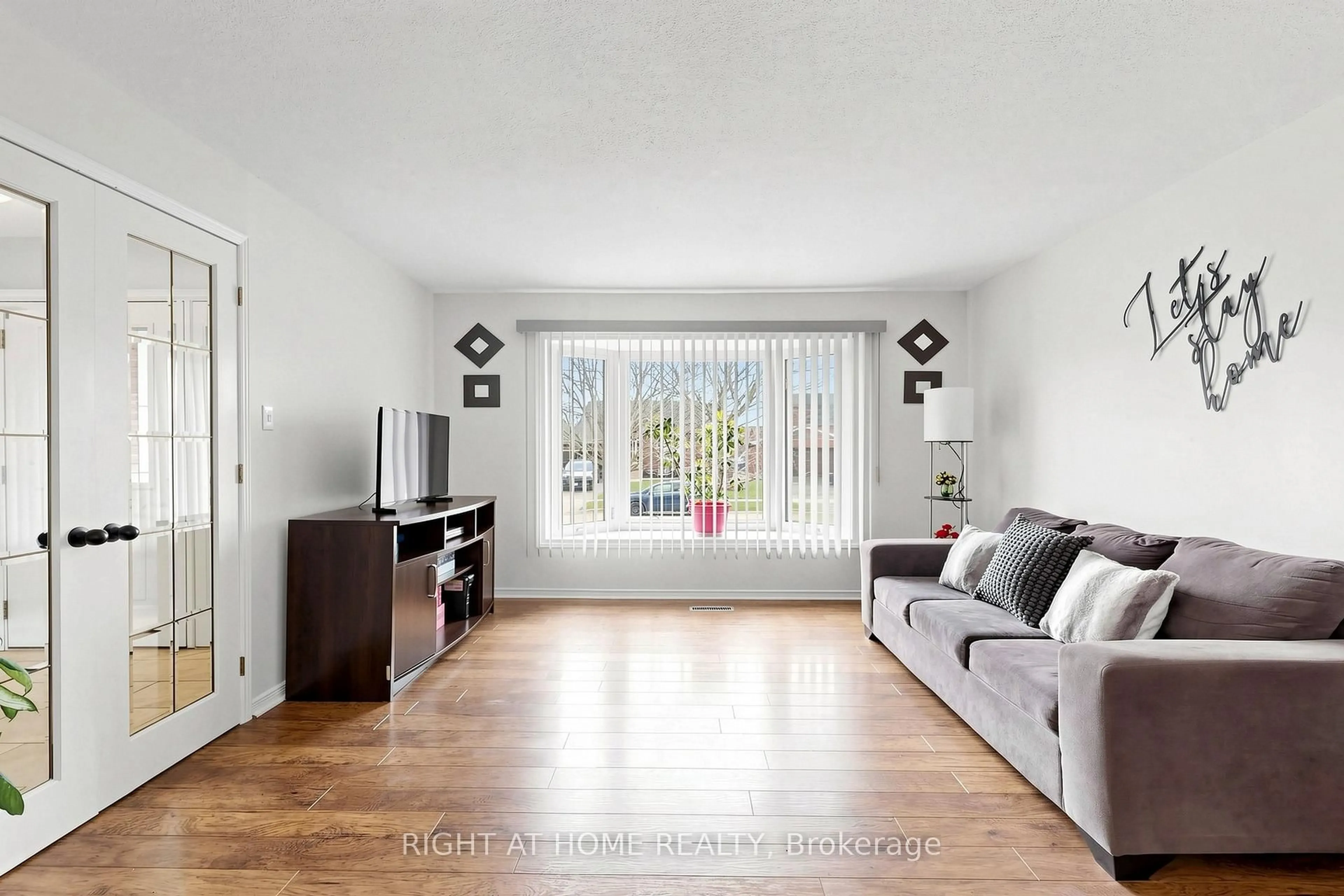 Living room with furniture, wood/laminate floor for 73 Pepler Pl, Barrie Ontario L4N 5E3