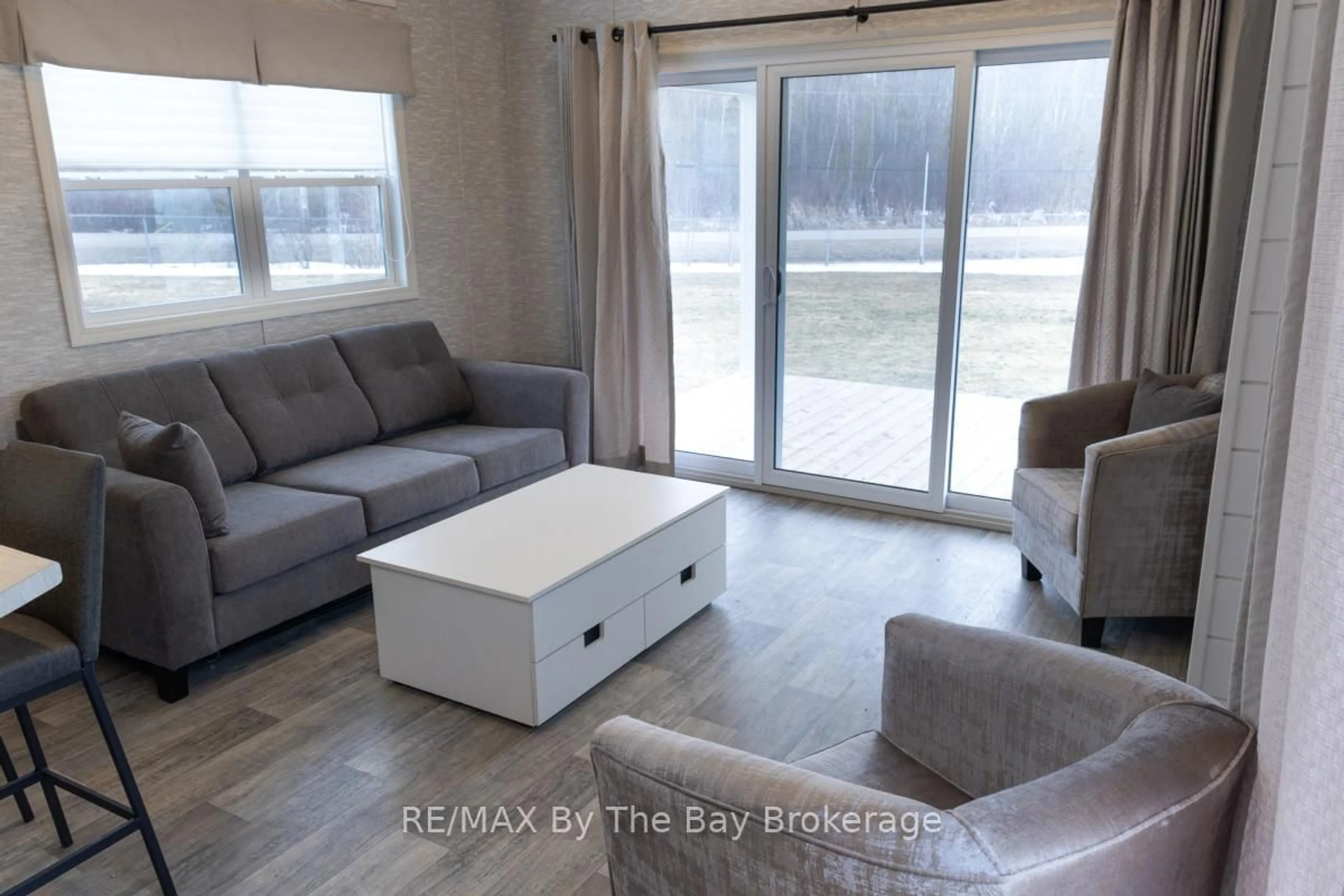Living room with furniture, wood/laminate floor for 3282 Ogdens Beach Rd #69, Tay Ontario L9S 2K6