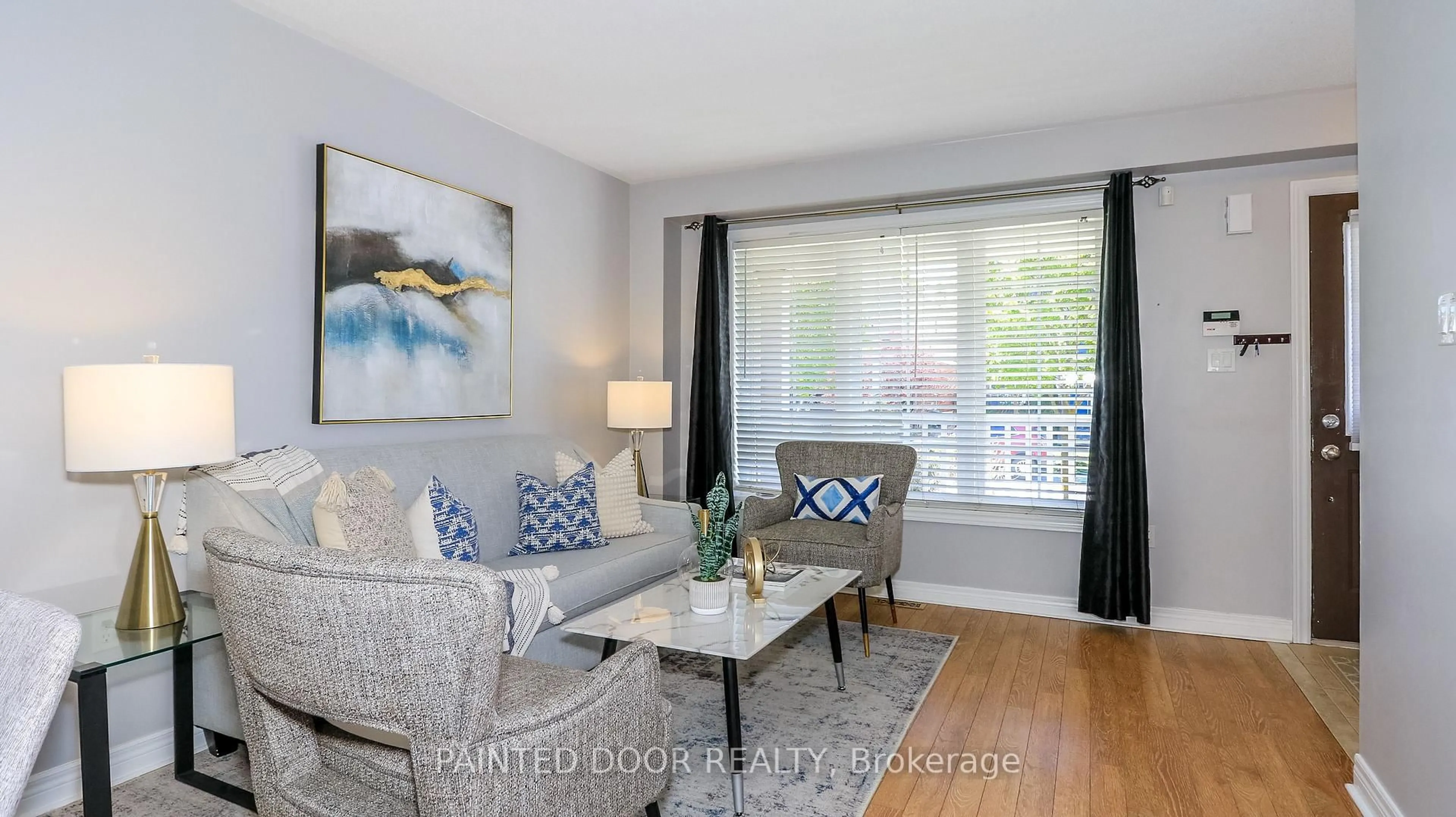 Living room with furniture, wood/laminate floor for 116 Thrushwood Dr, Barrie Ontario L4N 0Z1