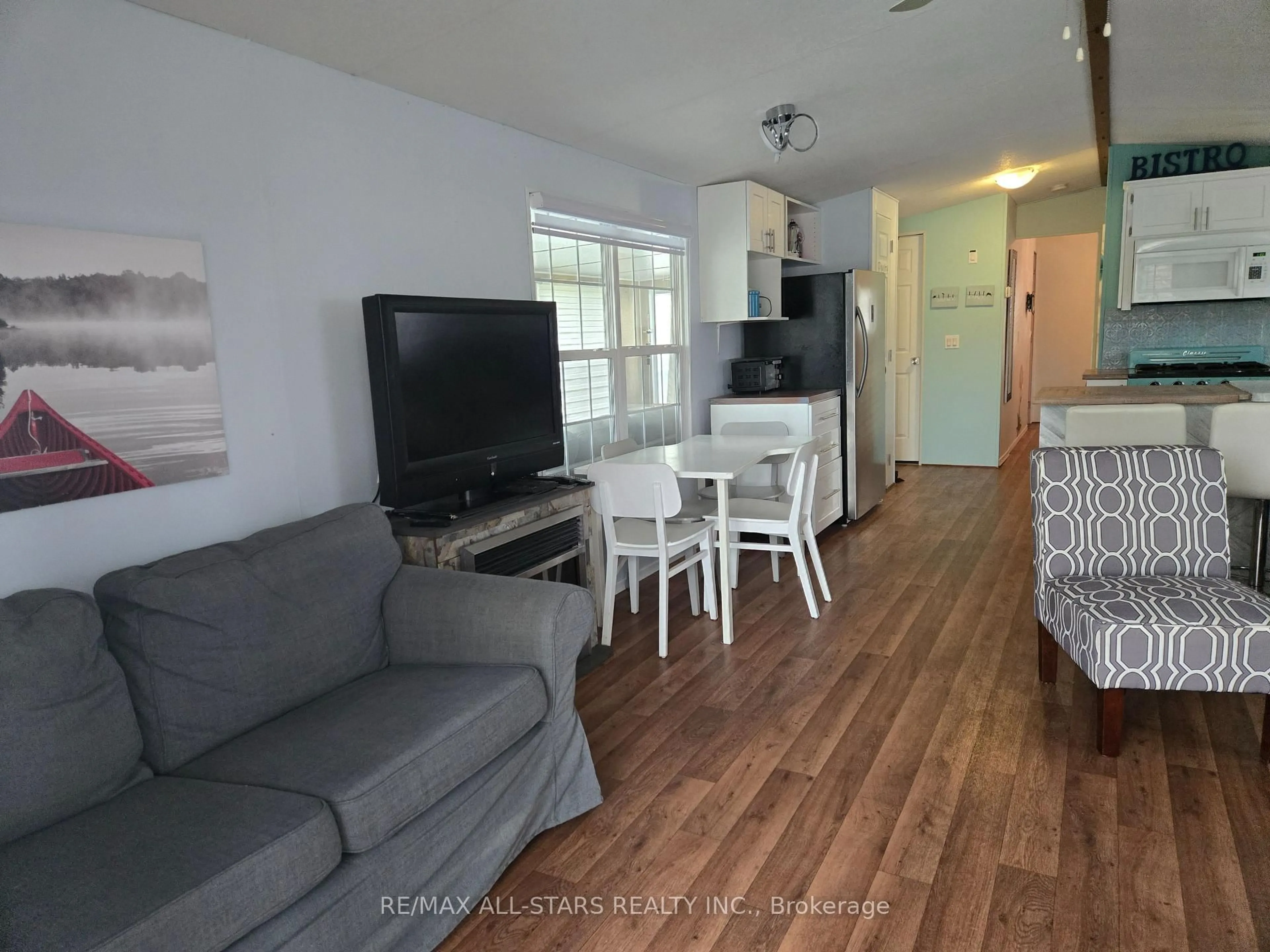 Living room with furniture, wood/laminate floor for 1 KENORA Tr, Wasaga Beach Ontario L9Z 1X7