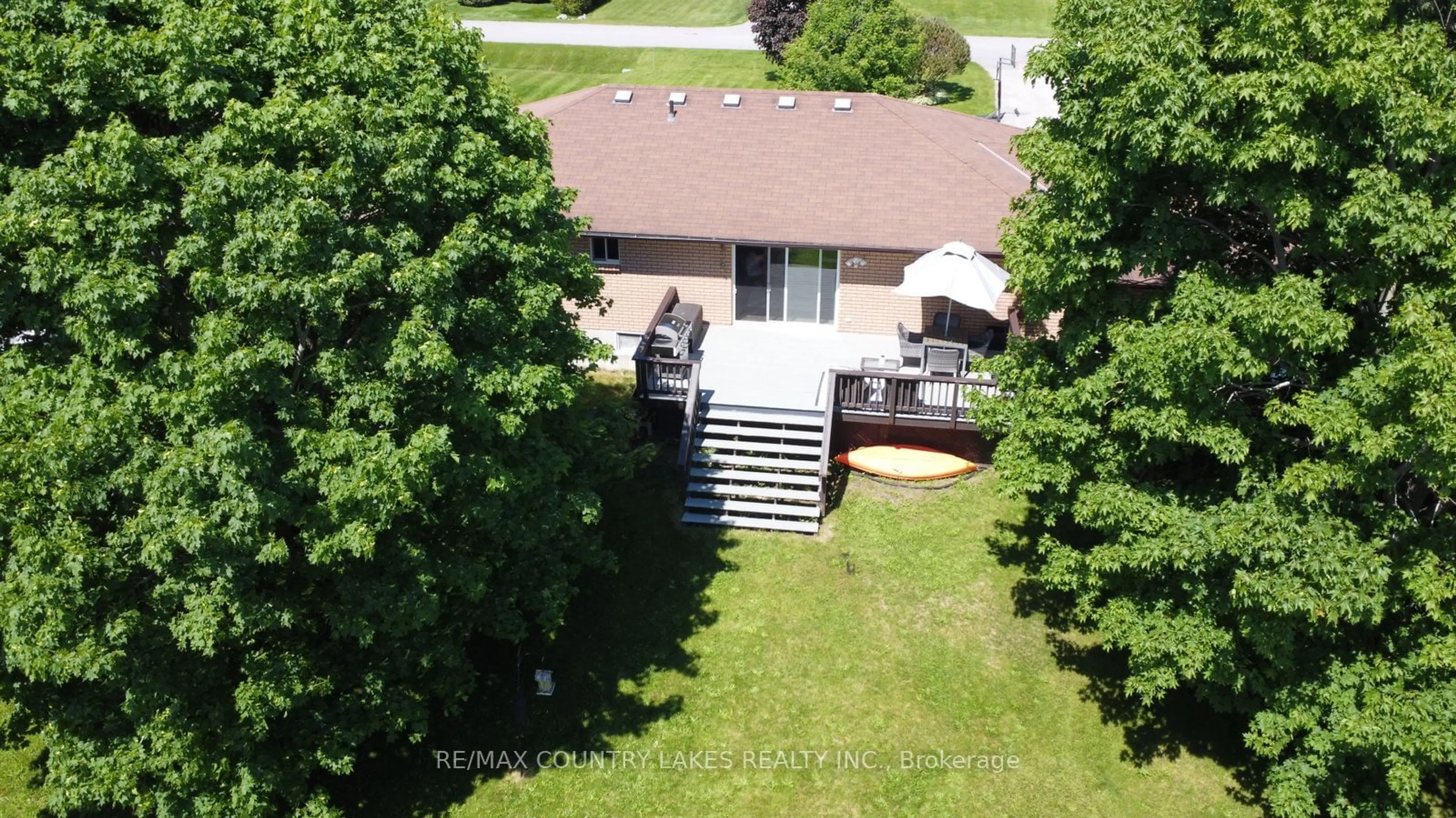 Frontside or backside of a home, the fenced backyard for 84 Pinewood Blvd, Kawartha Lakes Ontario K0M 2T0