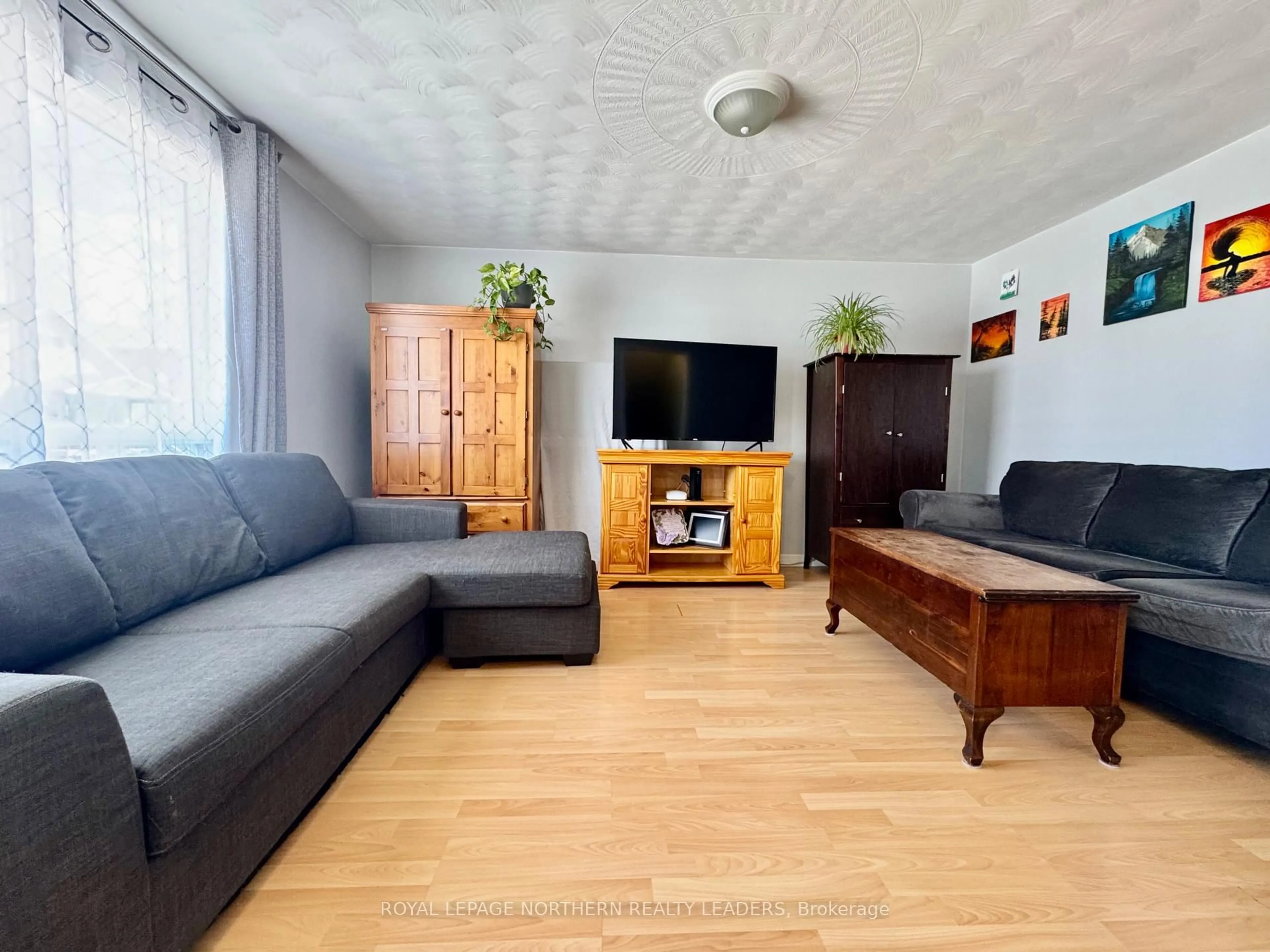 Living room with furniture, wood/laminate floor for 7 Borden Ave, Timmins Ontario P4N 4E6