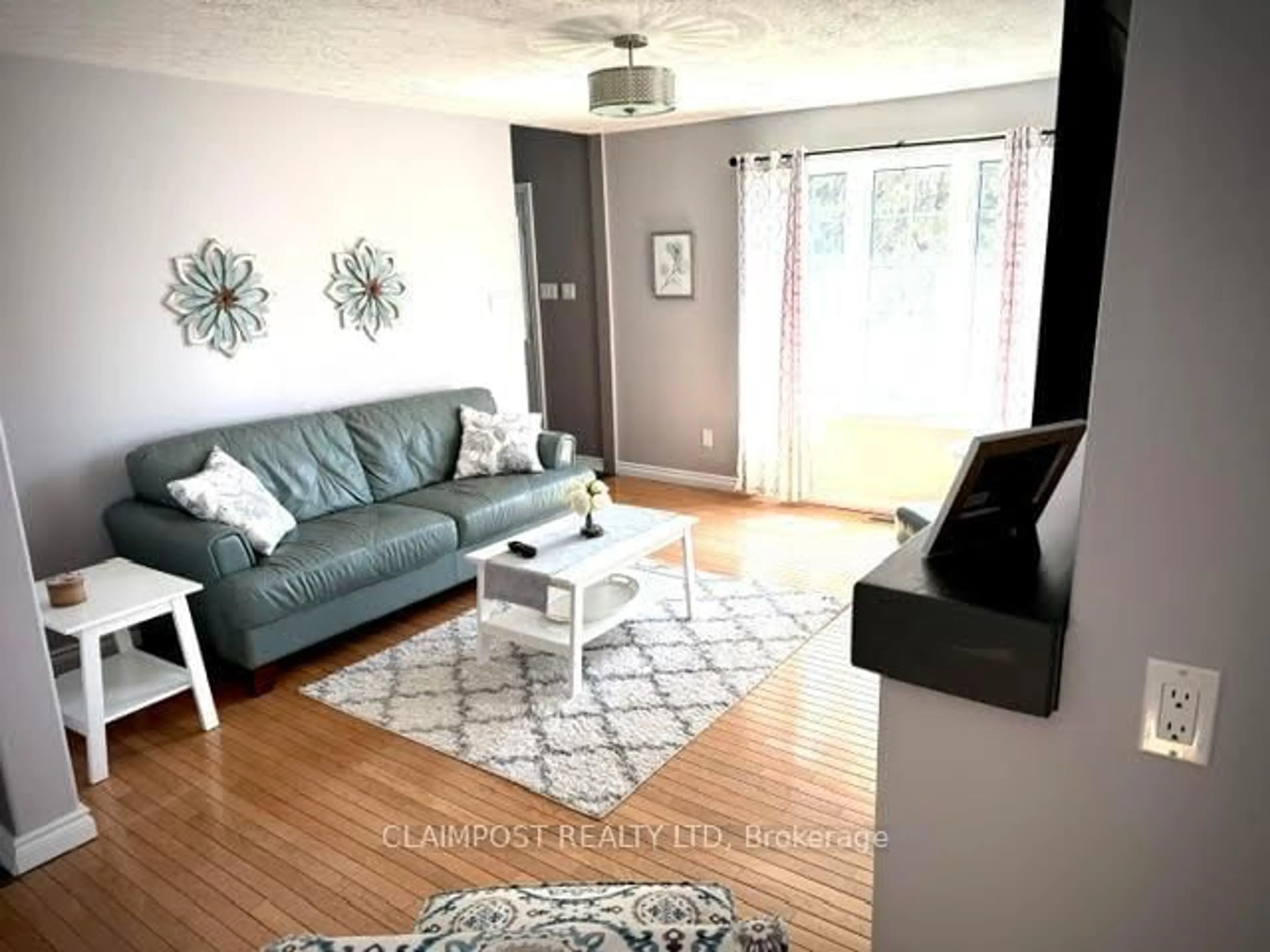 Living room with furniture, wood/laminate floor for 690 Howard Ave, Timmins Ontario P4N 5V8