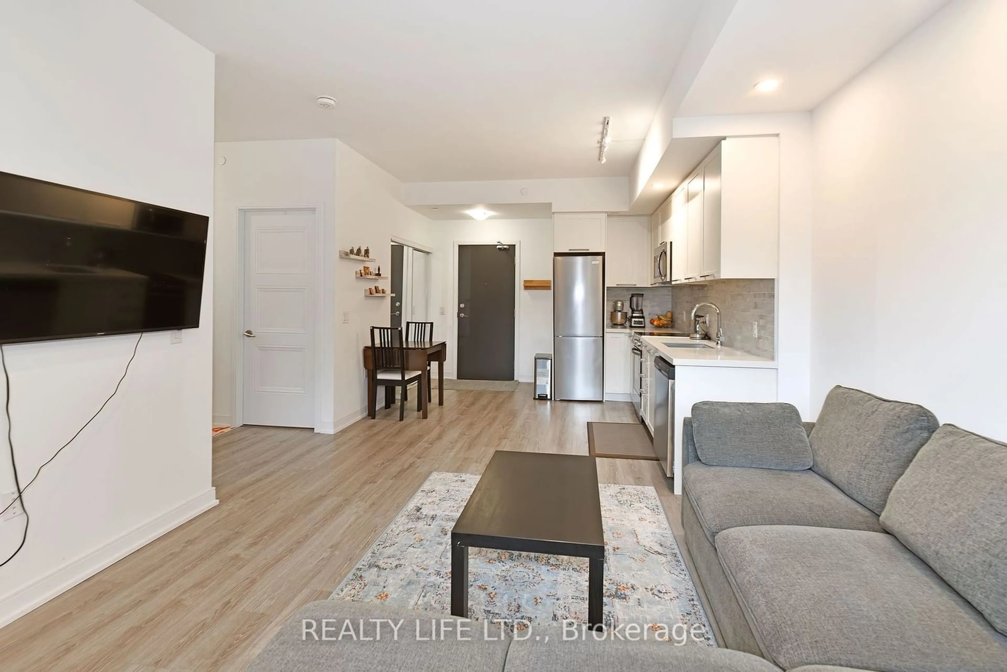 Living room with furniture, wood/laminate floor for 25 Neighbourhood Lane #310, Toronto Ontario M8Y 0C4