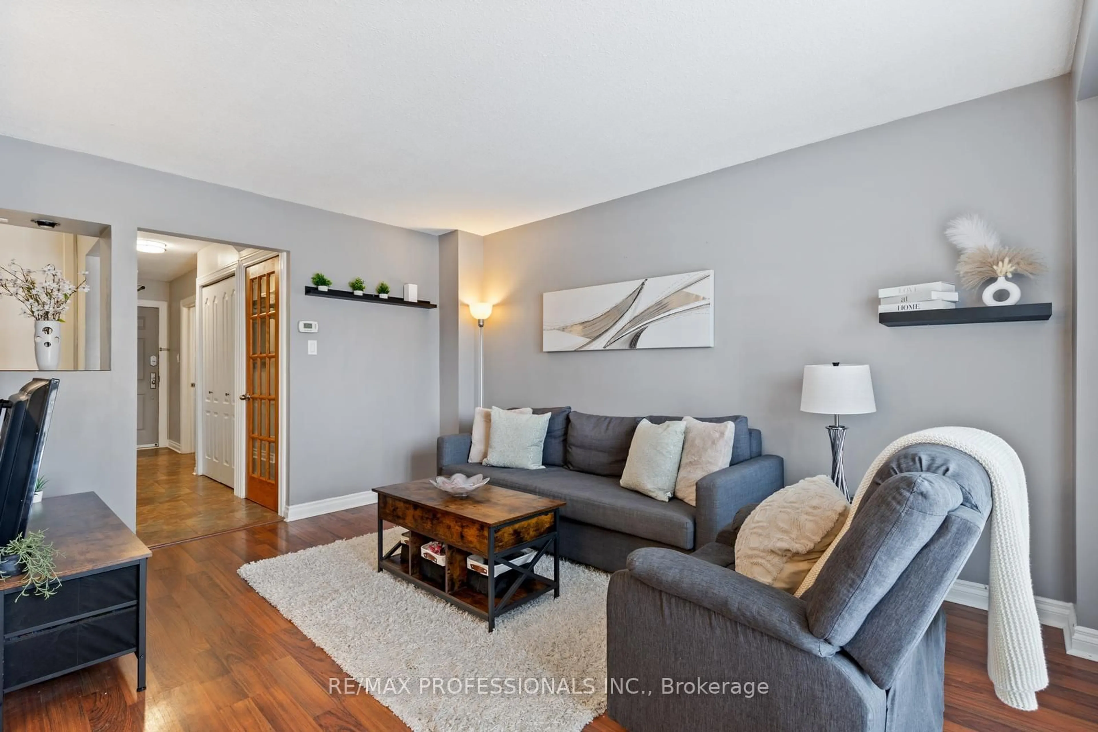 Living room with furniture, wood/laminate floor for 7430 Copenhagen Rd #107, Mississauga Ontario L5N 2C4