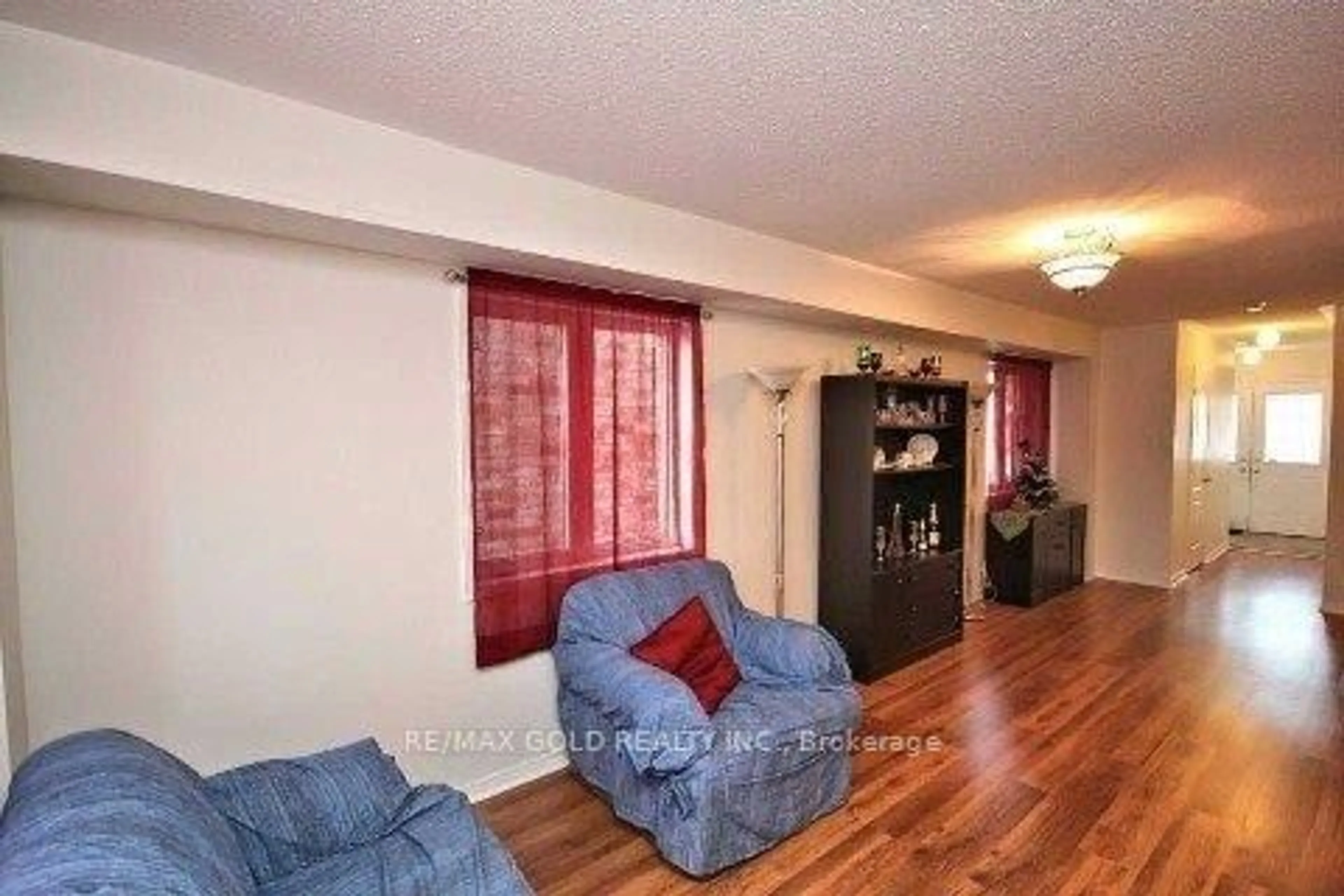 Living room with furniture, wood/laminate floor for 73 Roundstone Dr, Brampton Ontario L6X 0K4