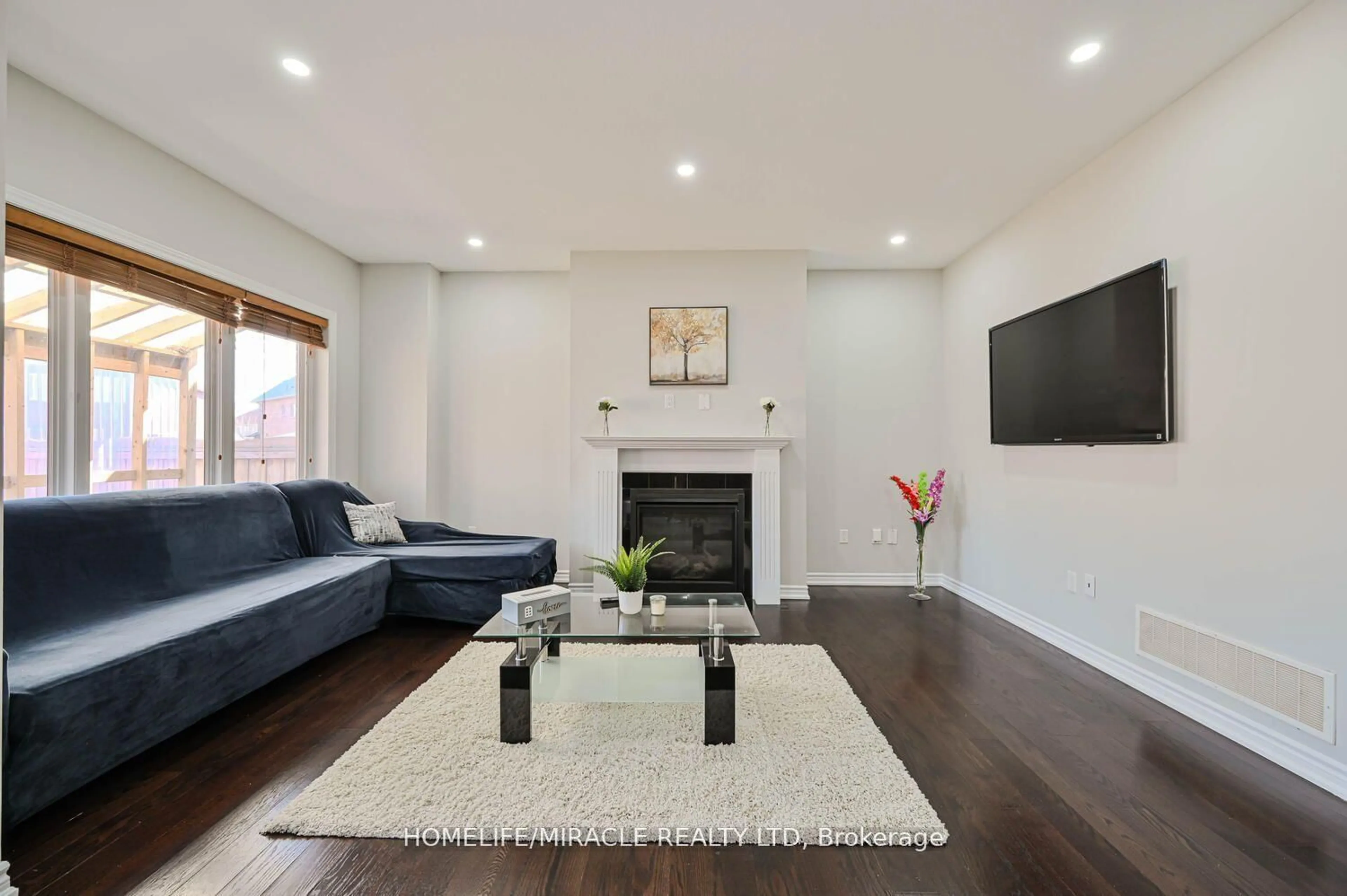 Living room with furniture, wood/laminate floor for 21 Magical Rd, Brampton Ontario L7A 4P8