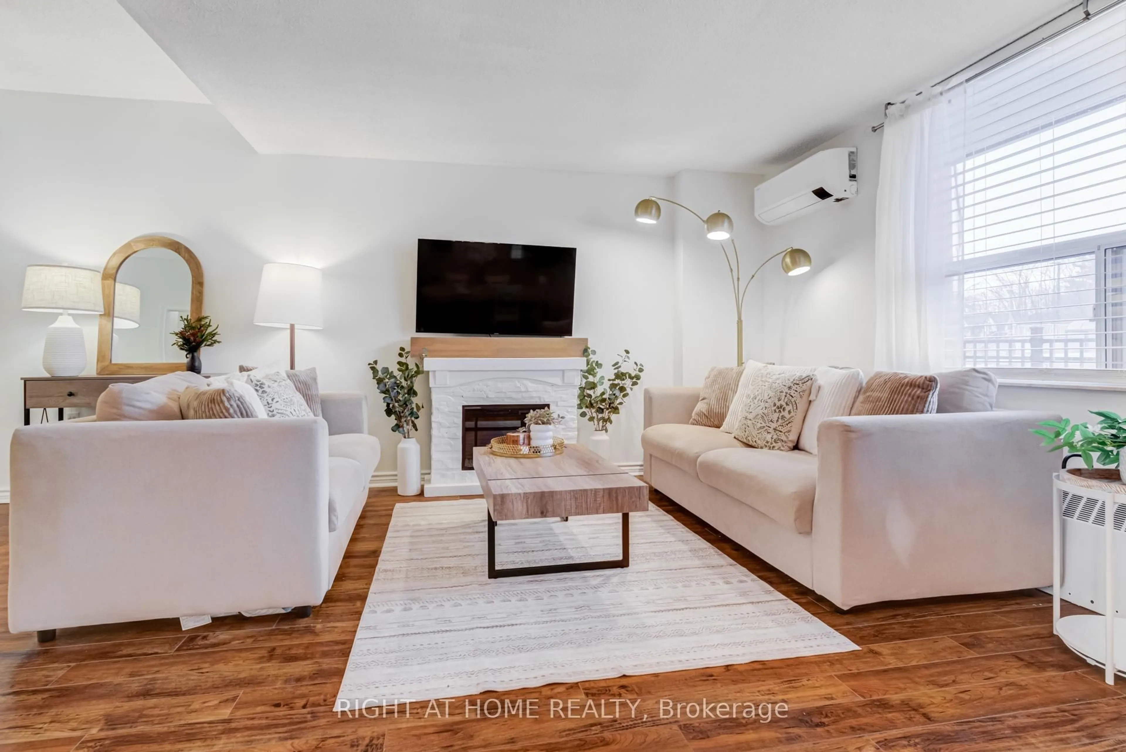 Living room with furniture, wood/laminate floor for 49 Queen St #101, Mississauga Ontario L5G 4N6
