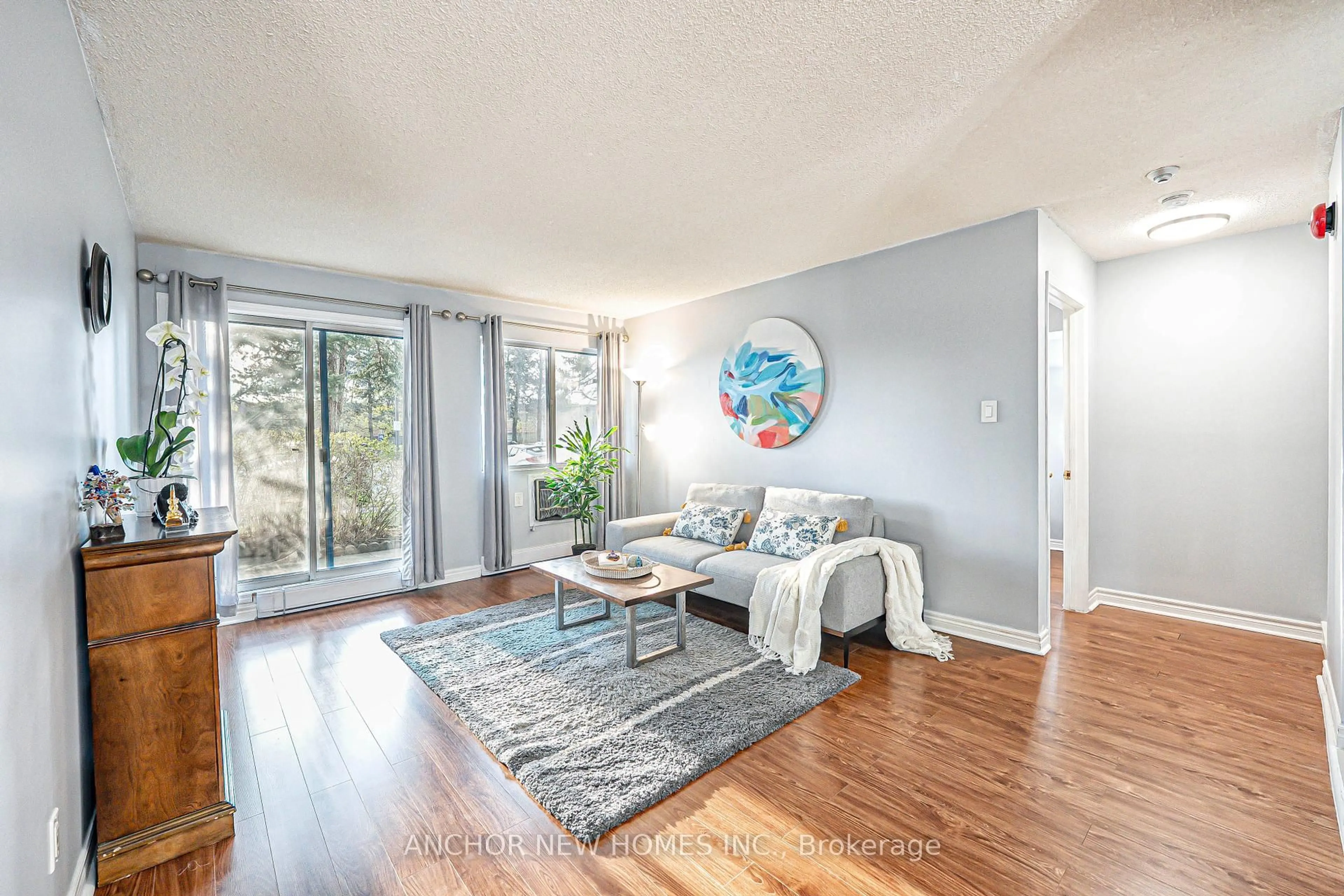 Living room with furniture, wood/laminate floor for 65 Trailwood Dr #213, Mississauga Ontario L4Z 3L1