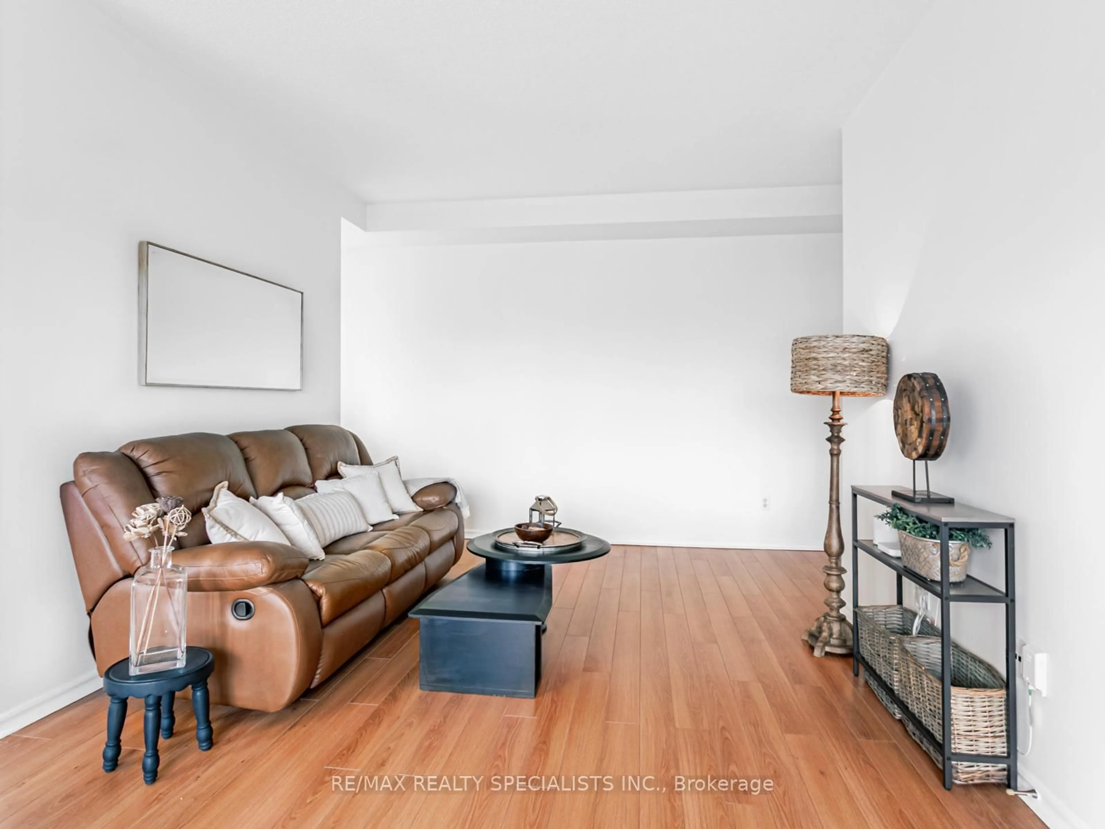 Living room with furniture, wood/laminate floor for 30 Malta Ave #106, Brampton Ontario L6Y 4S5