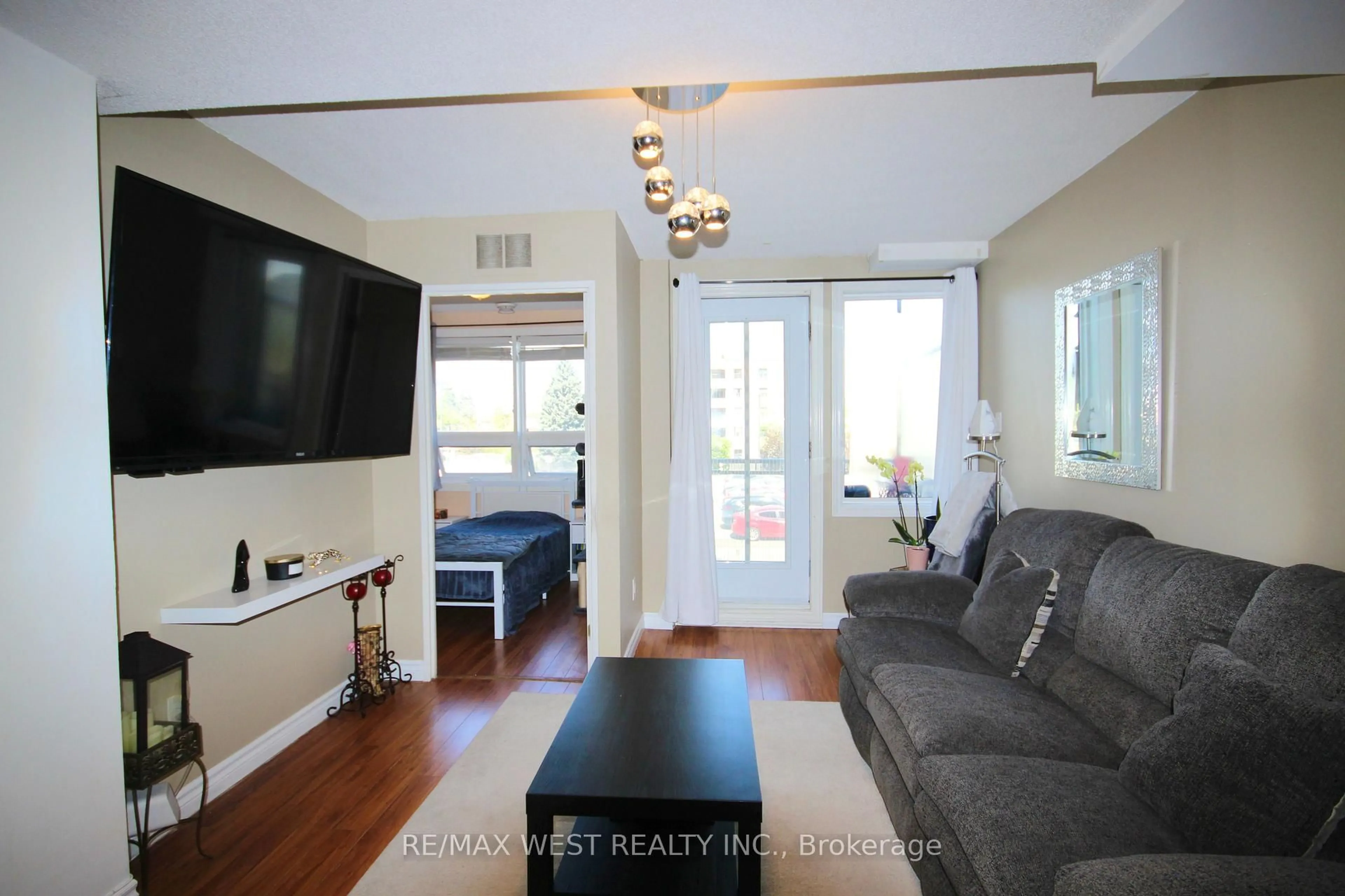 Living room with furniture, wood/laminate floor for 7405 Goreway Dr #202, Mississauga Ontario L4T 0A3
