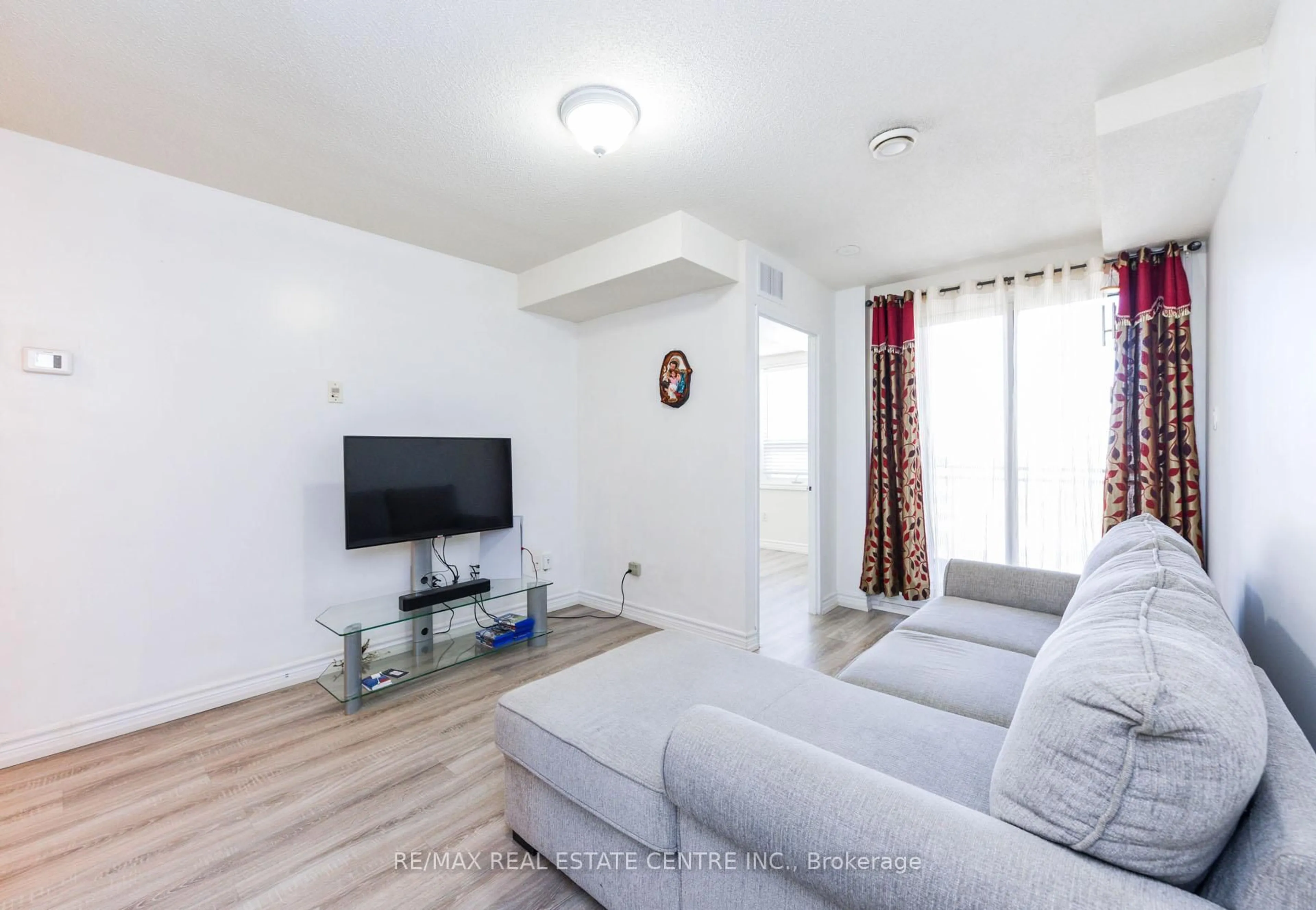 Living room with furniture, wood/laminate floor for 7405 Goreway Dr #520, Mississauga Ontario L4T 0A2