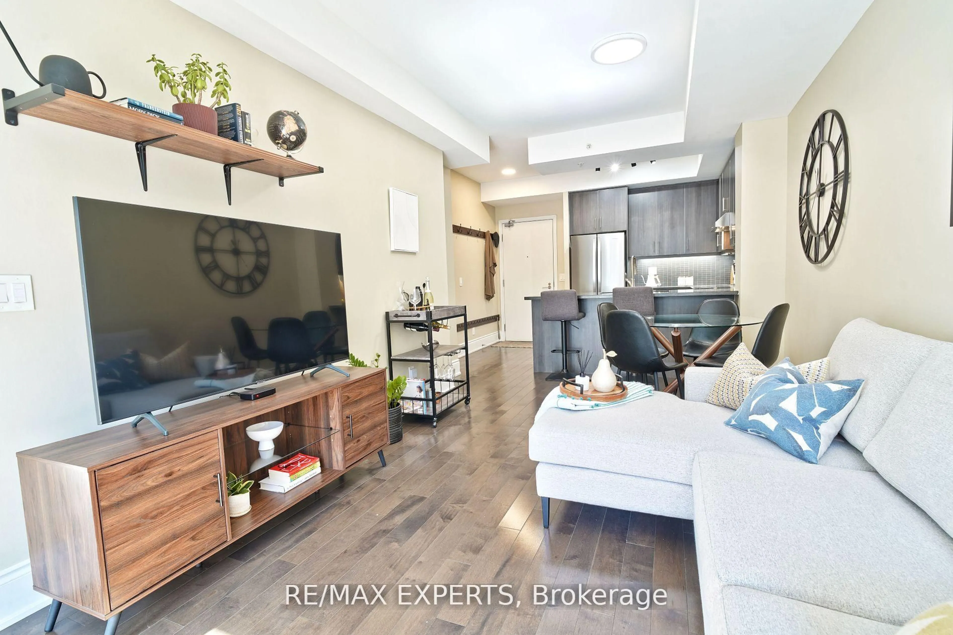 Living room with furniture, wood/laminate floor for 15 James Finlay Way #1017, Toronto Ontario M3M 0A2