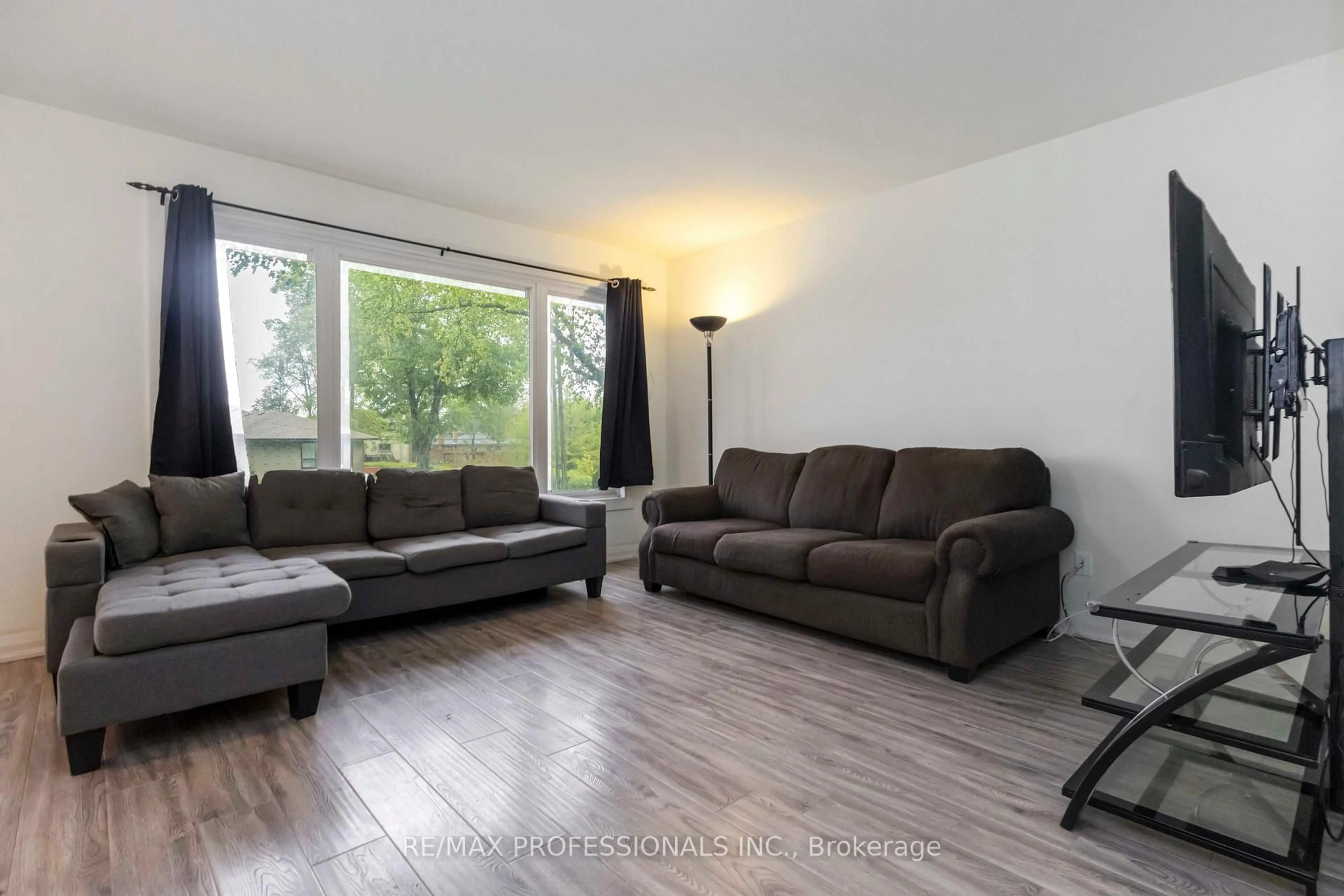 Living room with furniture, wood/laminate floor for 21 Caulfield Rd, Toronto Ontario M9W 1X1