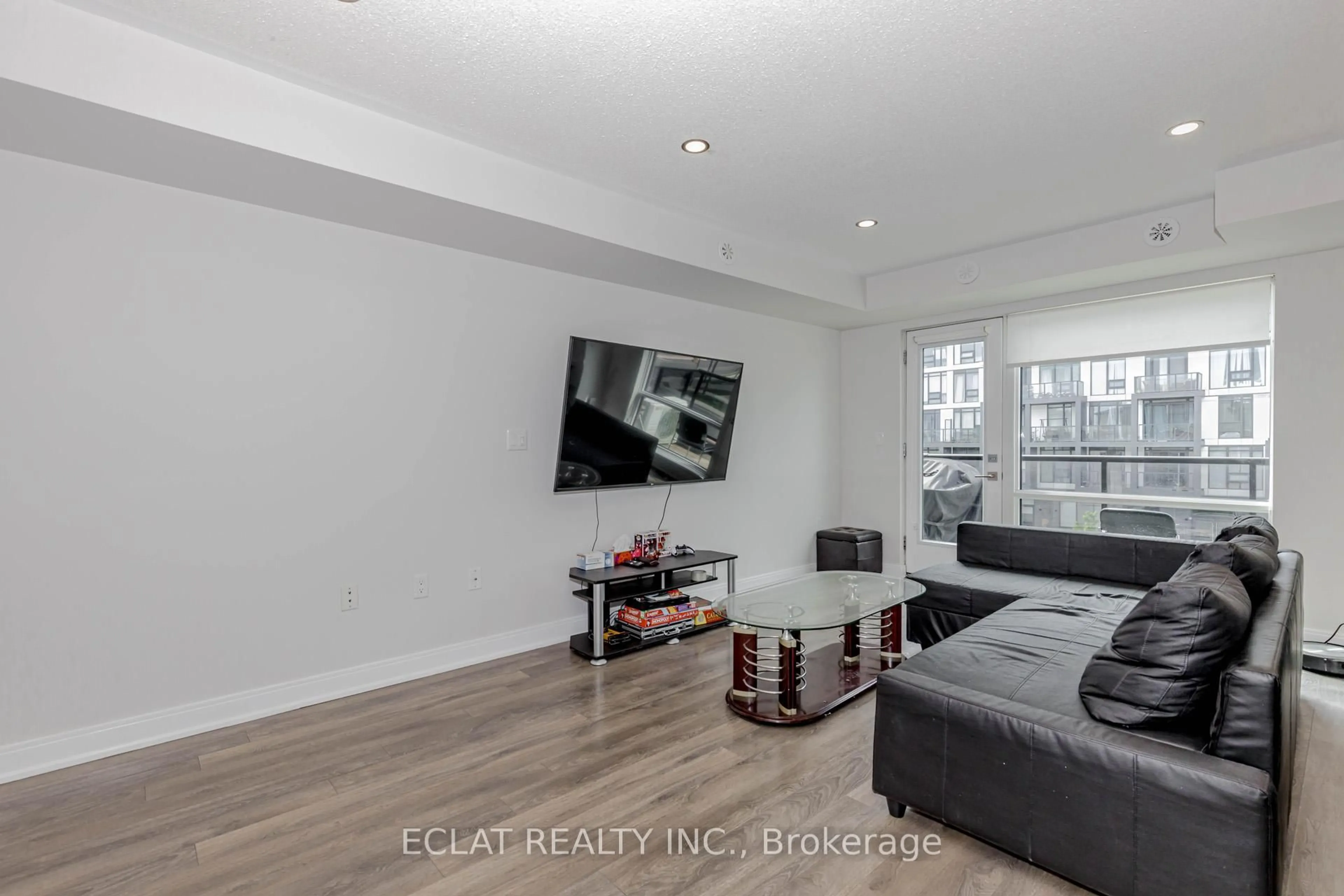 Living room with furniture, wood/laminate floor for 100 Dufay Rd #100, Brampton Ontario L7A 4S3