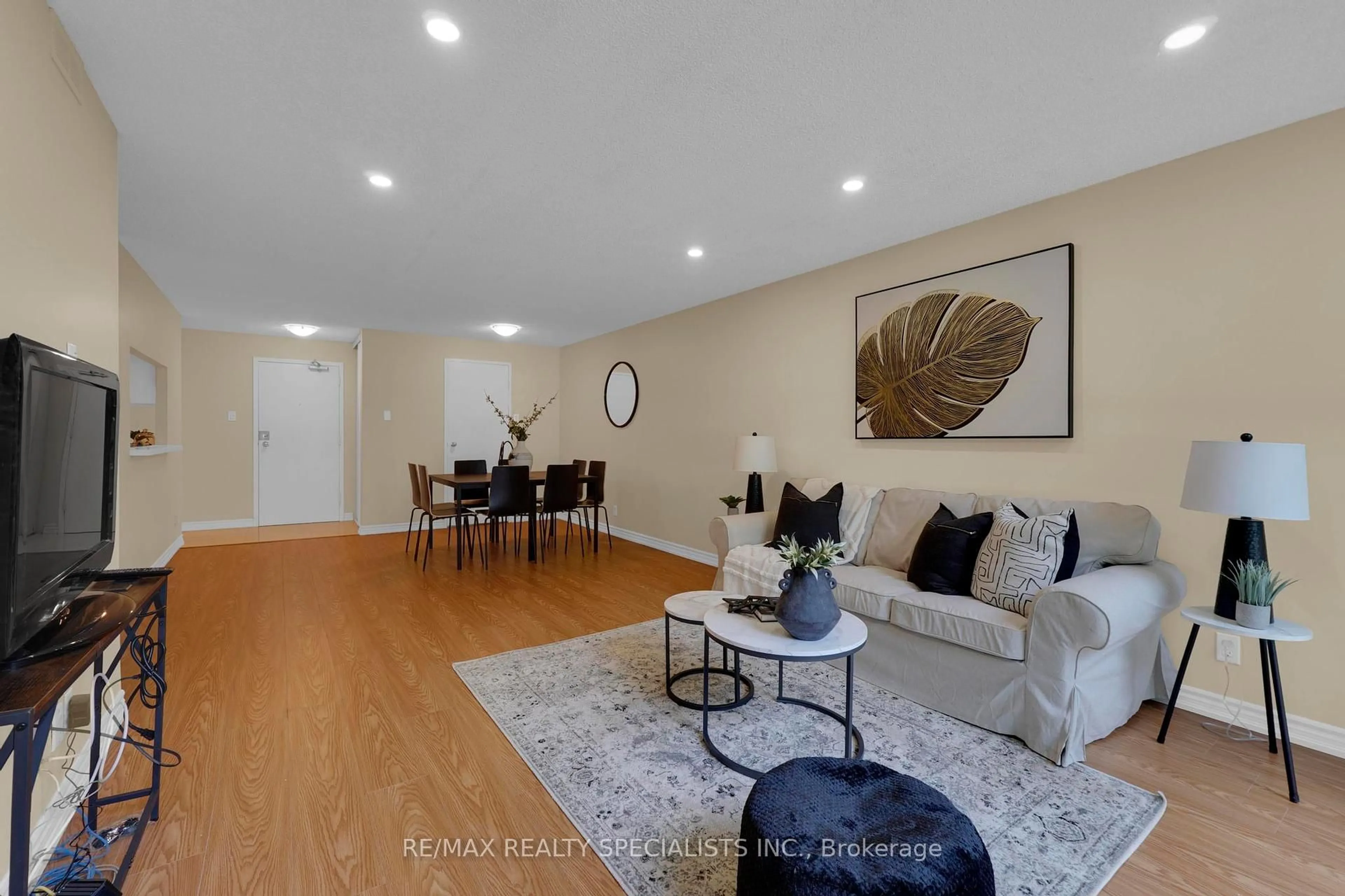 Living room with furniture, wood/laminate floor for 35 Trailwood Dr #113, Mississauga Ontario L4Z 3L6
