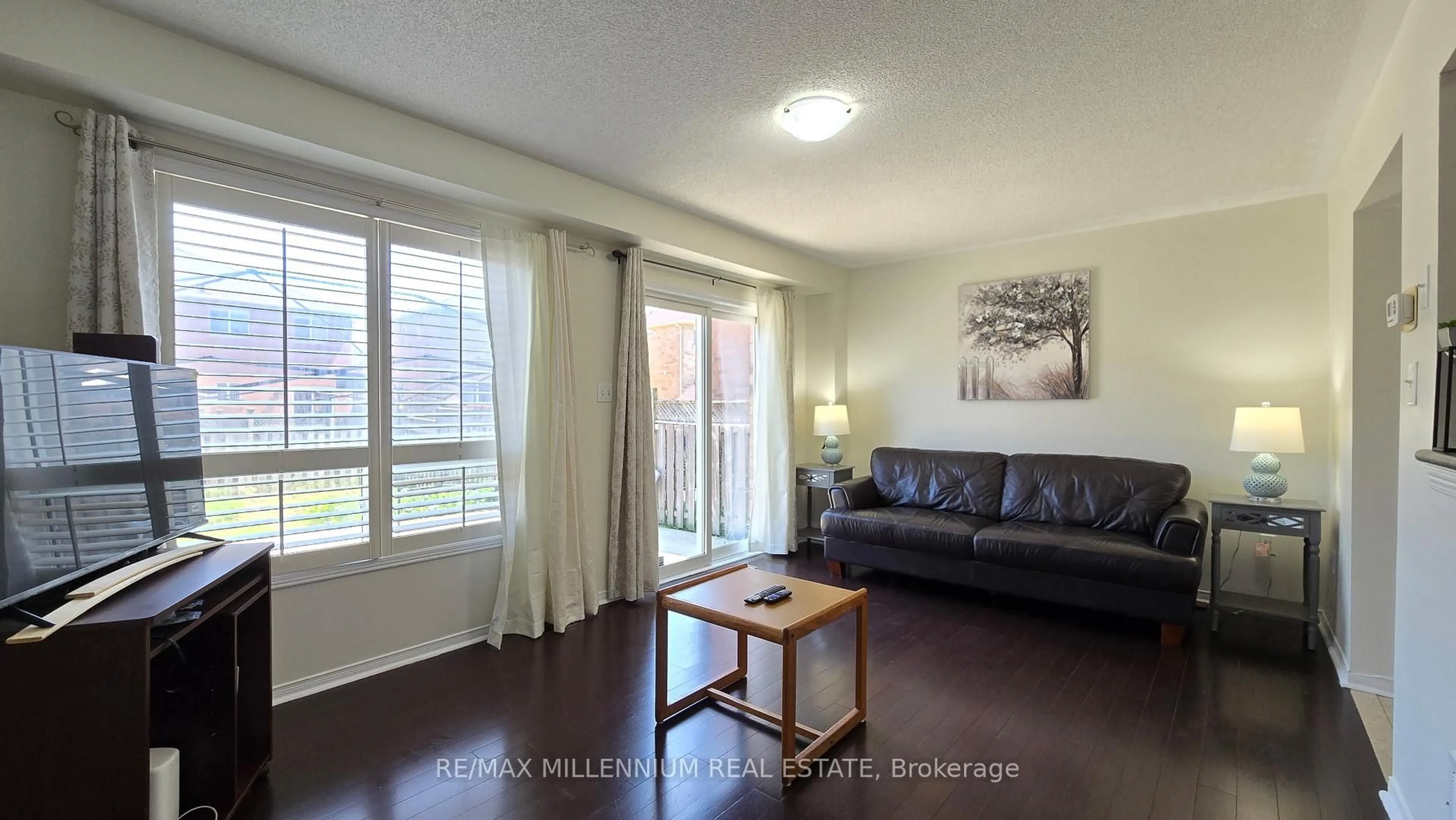 Living room with furniture, wood/laminate floor for 63 Roadmaster Lane, Brampton Ontario L7A 3A7