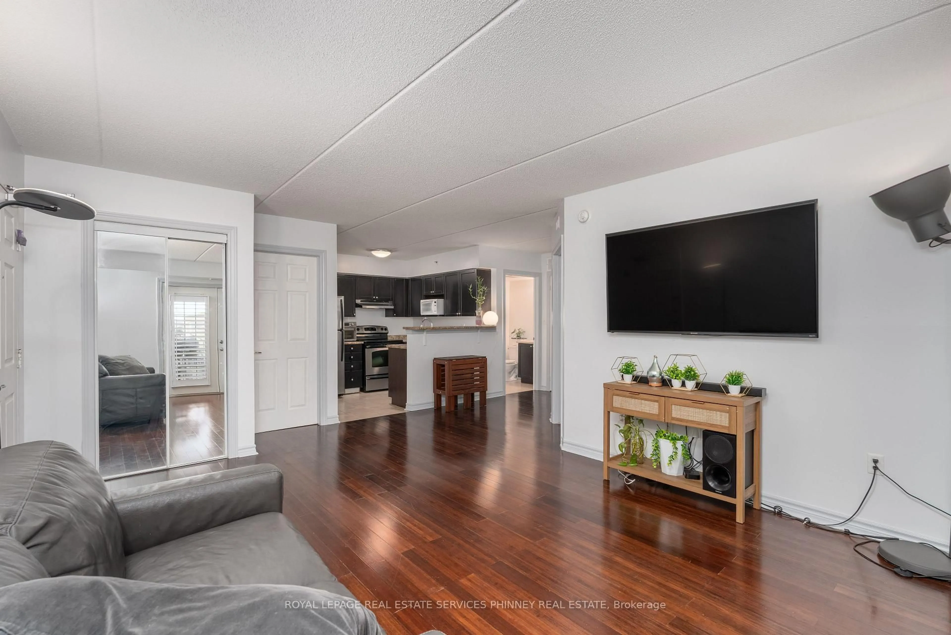Living room with furniture, wood/laminate floor for 1350 Main St #208, Milton Ontario L9T 7S7