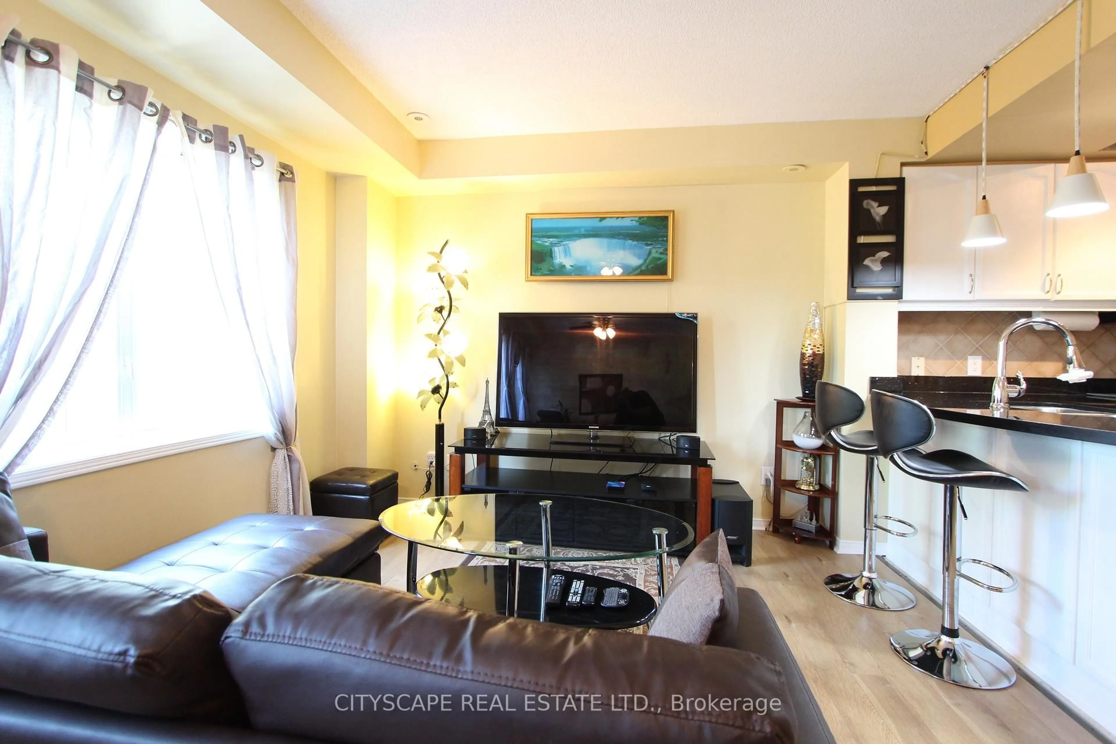 Living room with furniture, wood/laminate floor for 3055 Elmcreek Rd ##7, Mississauga Ontario L5B 4J9