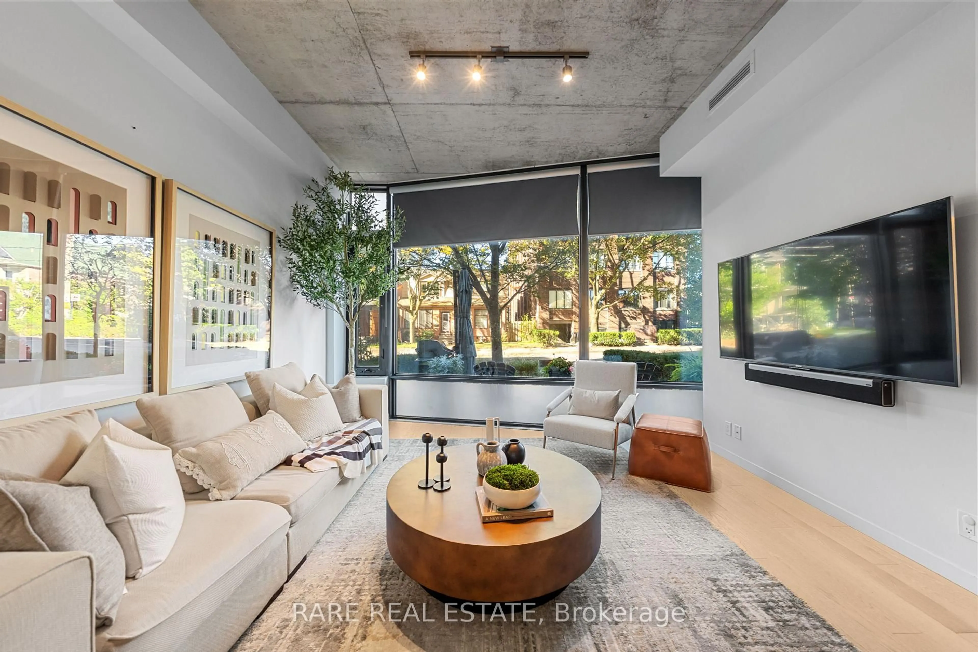 Living room with furniture, cement floor for 377 Sorauren Ave #102, Toronto Ontario M6R 0A4