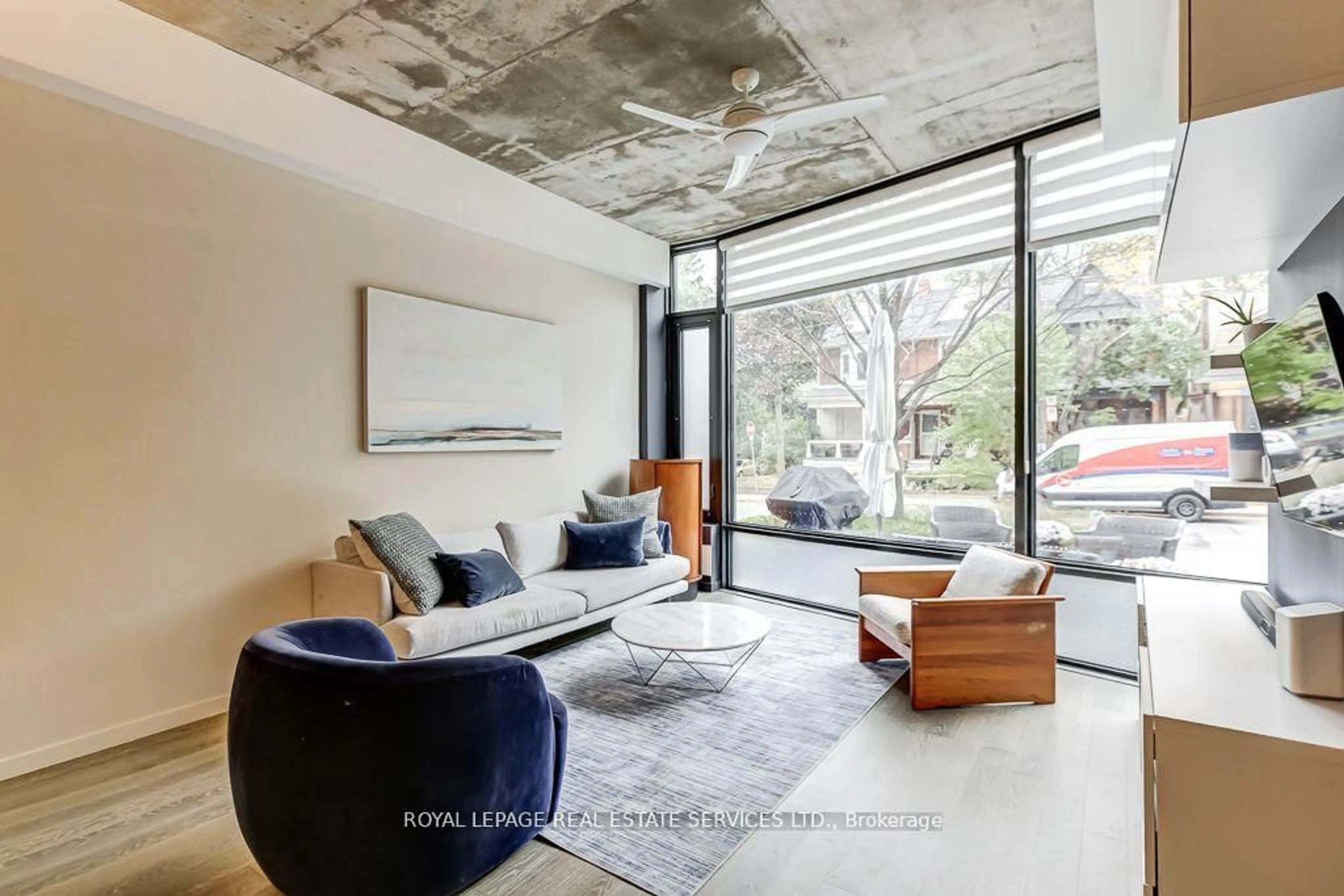 Living room with furniture, cement floor for 373 Sorauren Ave, Toronto Ontario M6R 0A4