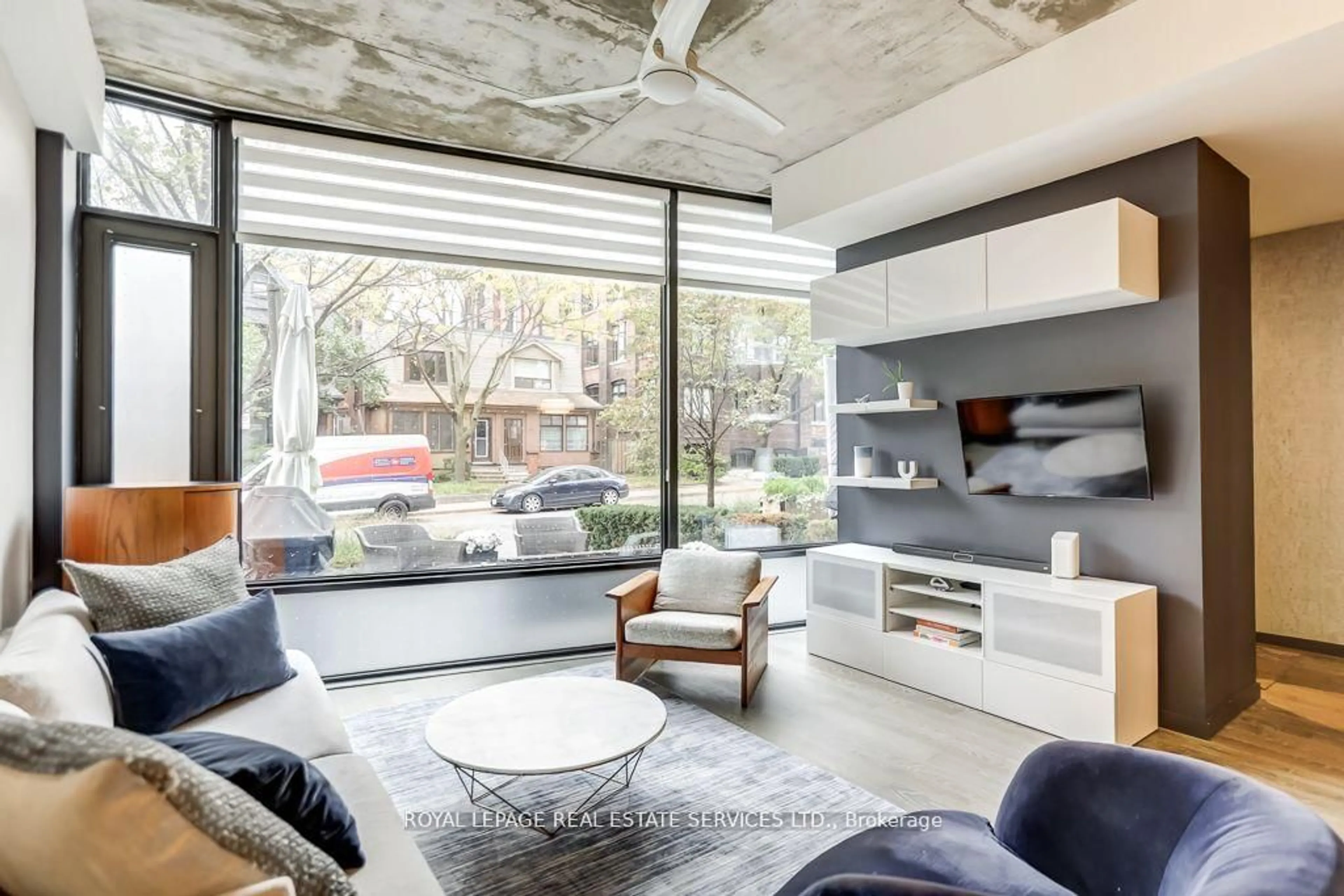 Living room with furniture, cement floor for 373 Sorauren Ave, Toronto Ontario M6R 0A4