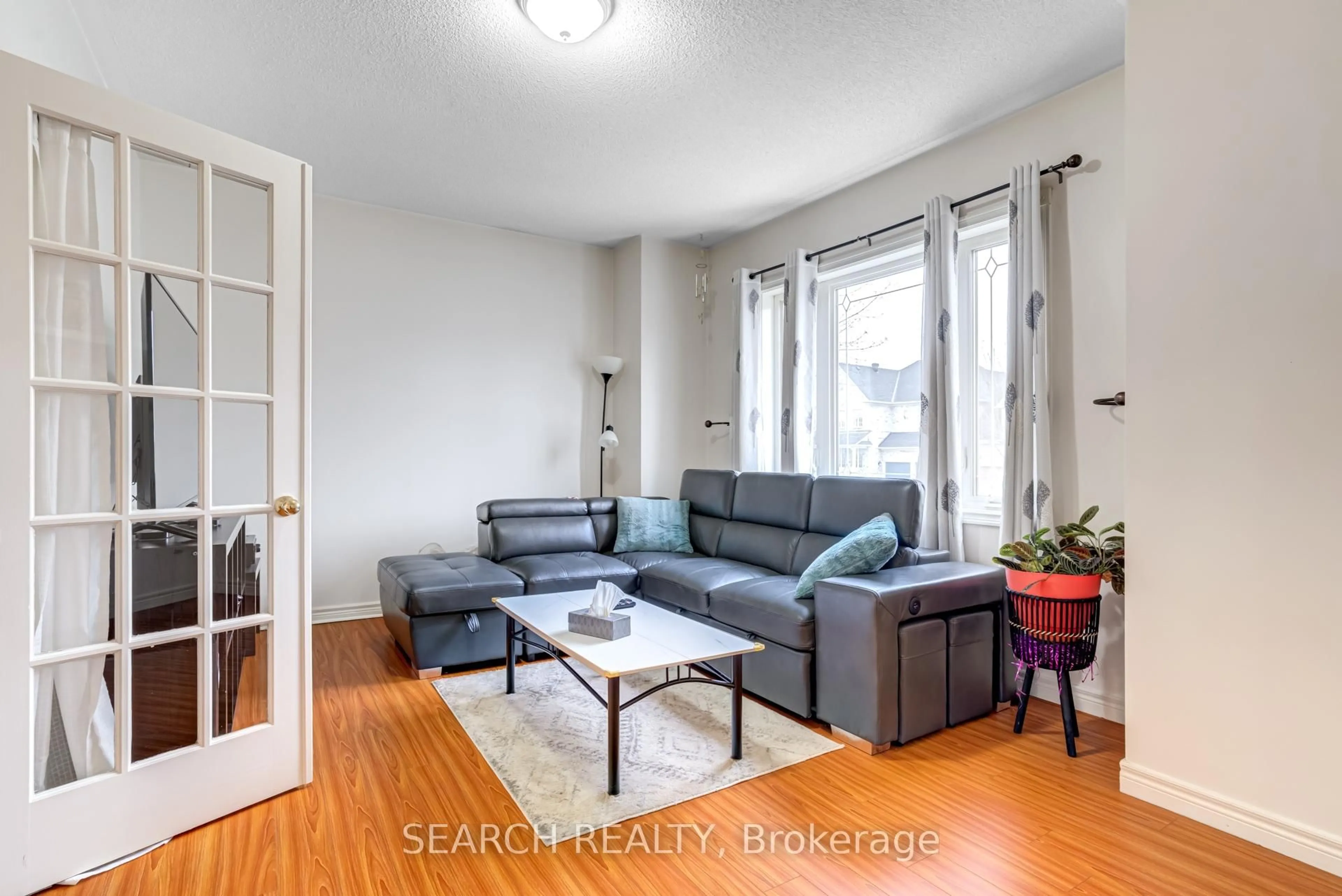 Living room with furniture, wood/laminate floor for 19 Treeline Blvd, Brampton Ontario L6P 1C5