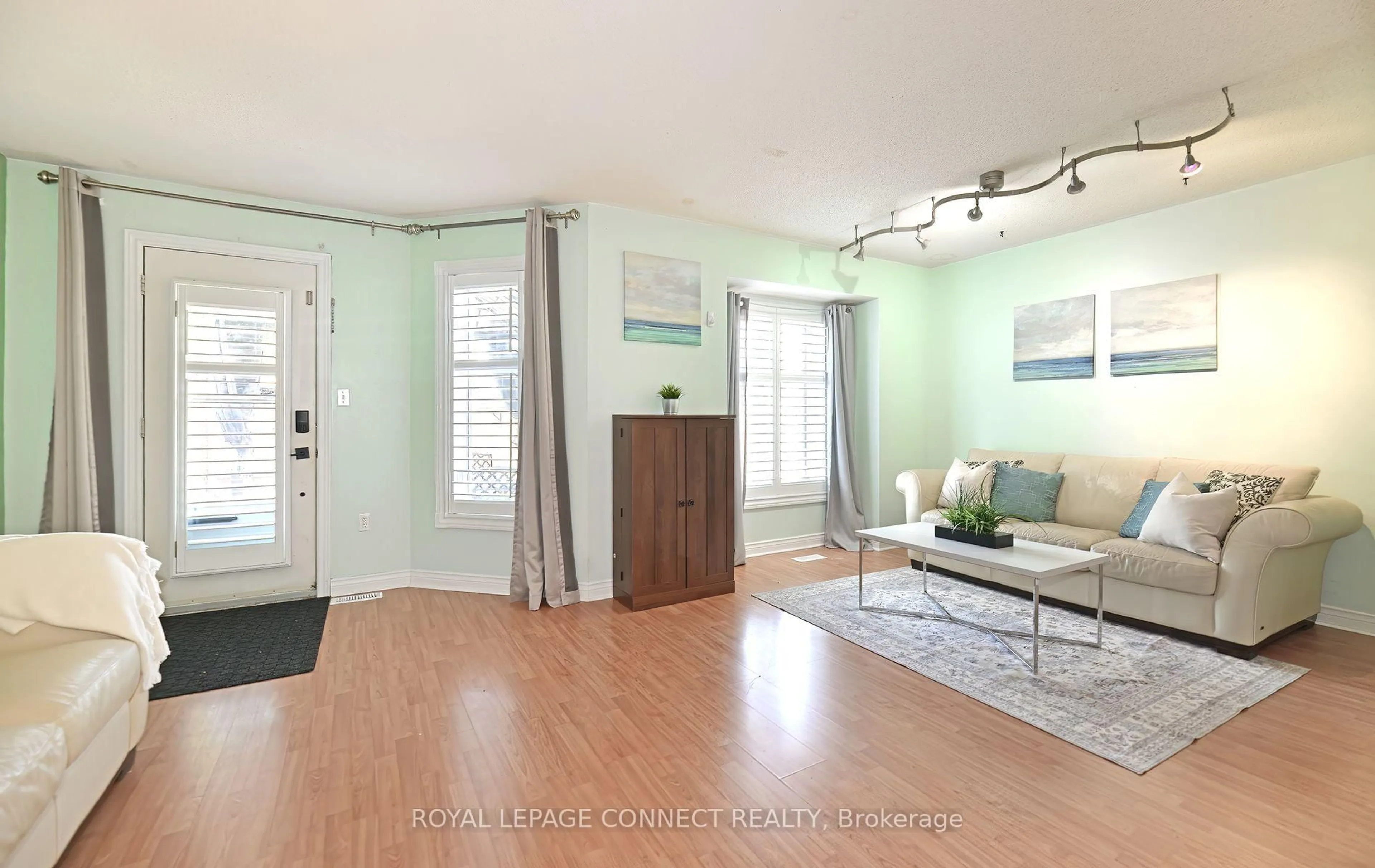 Living room with furniture, wood/laminate floor for 154 Pressed Brick Dr, Brampton Ontario L6V 4K6