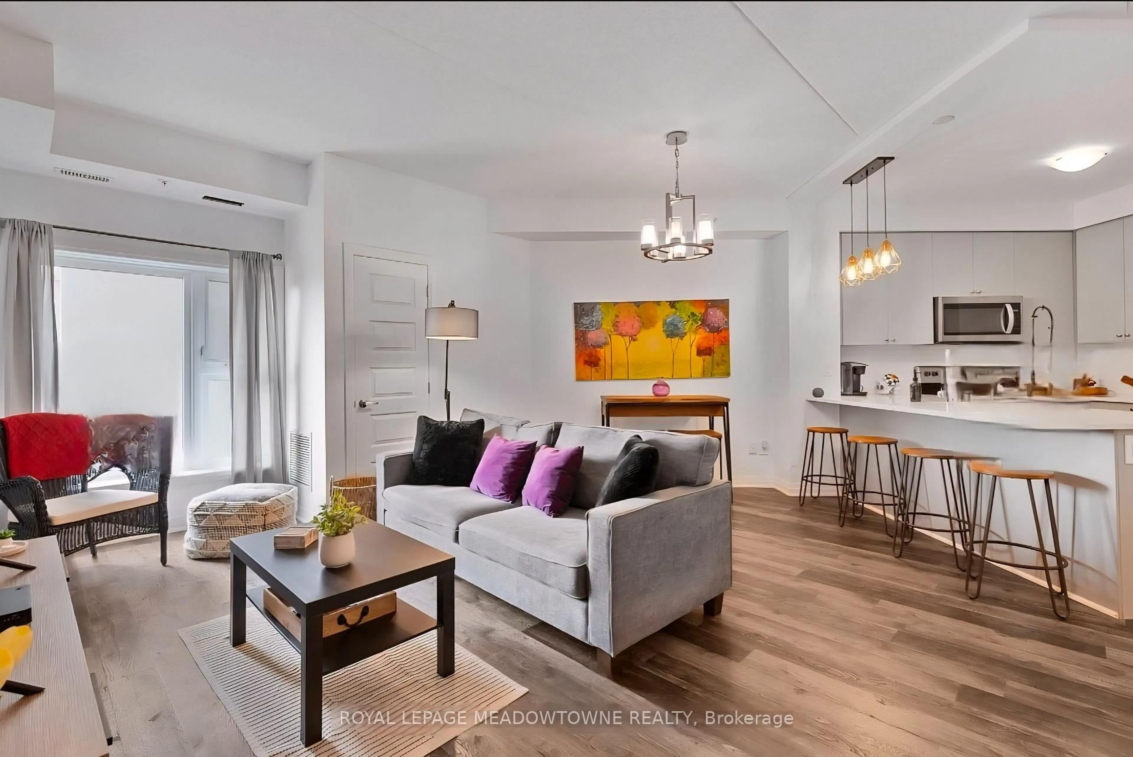 Living room with furniture, wood/laminate floor for 610 Farmstead Dr #324, Milton Ontario L9T 8X5