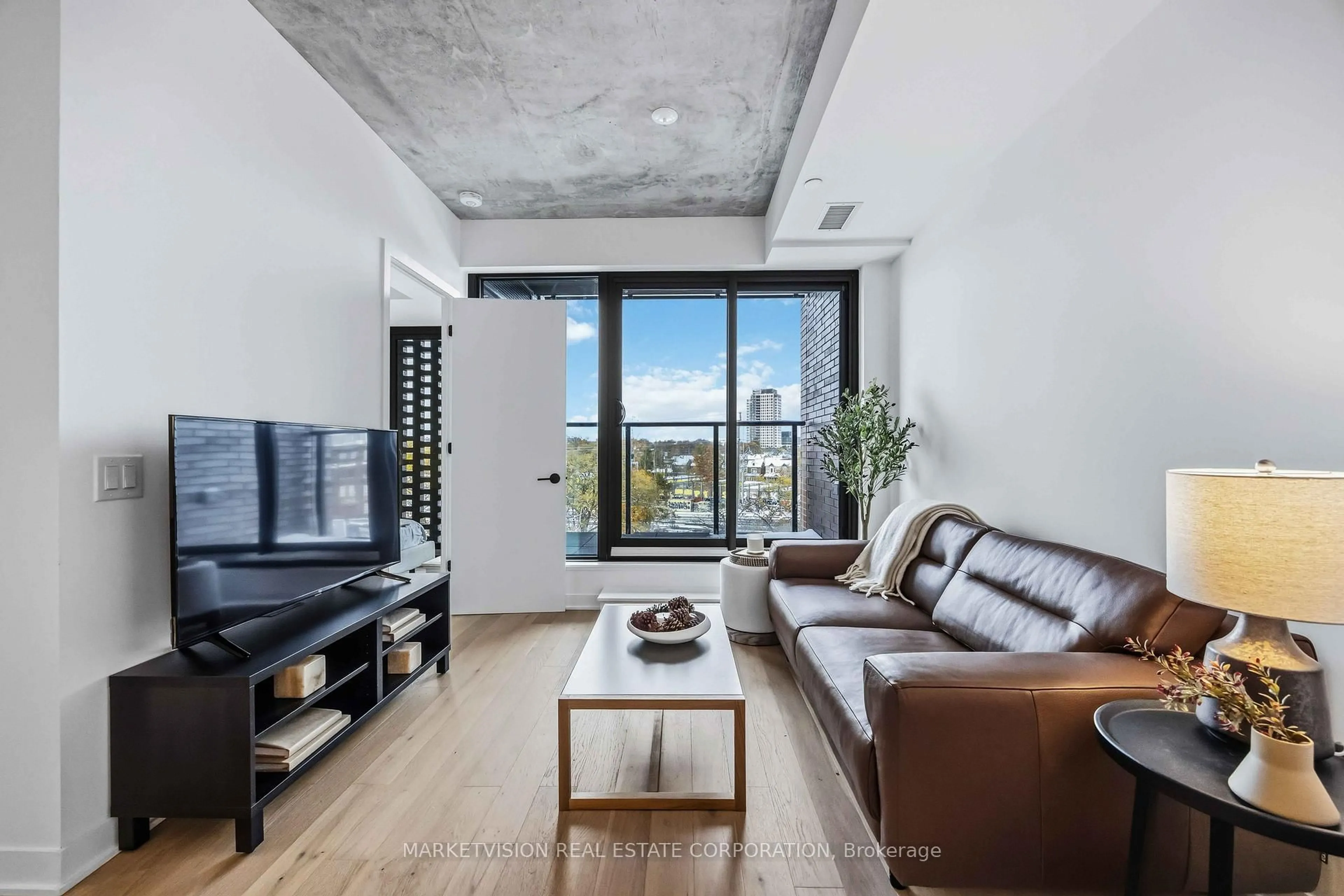 Living room with furniture, cement floor for 2625 Dundas St #506, Toronto Ontario M6P 1X9