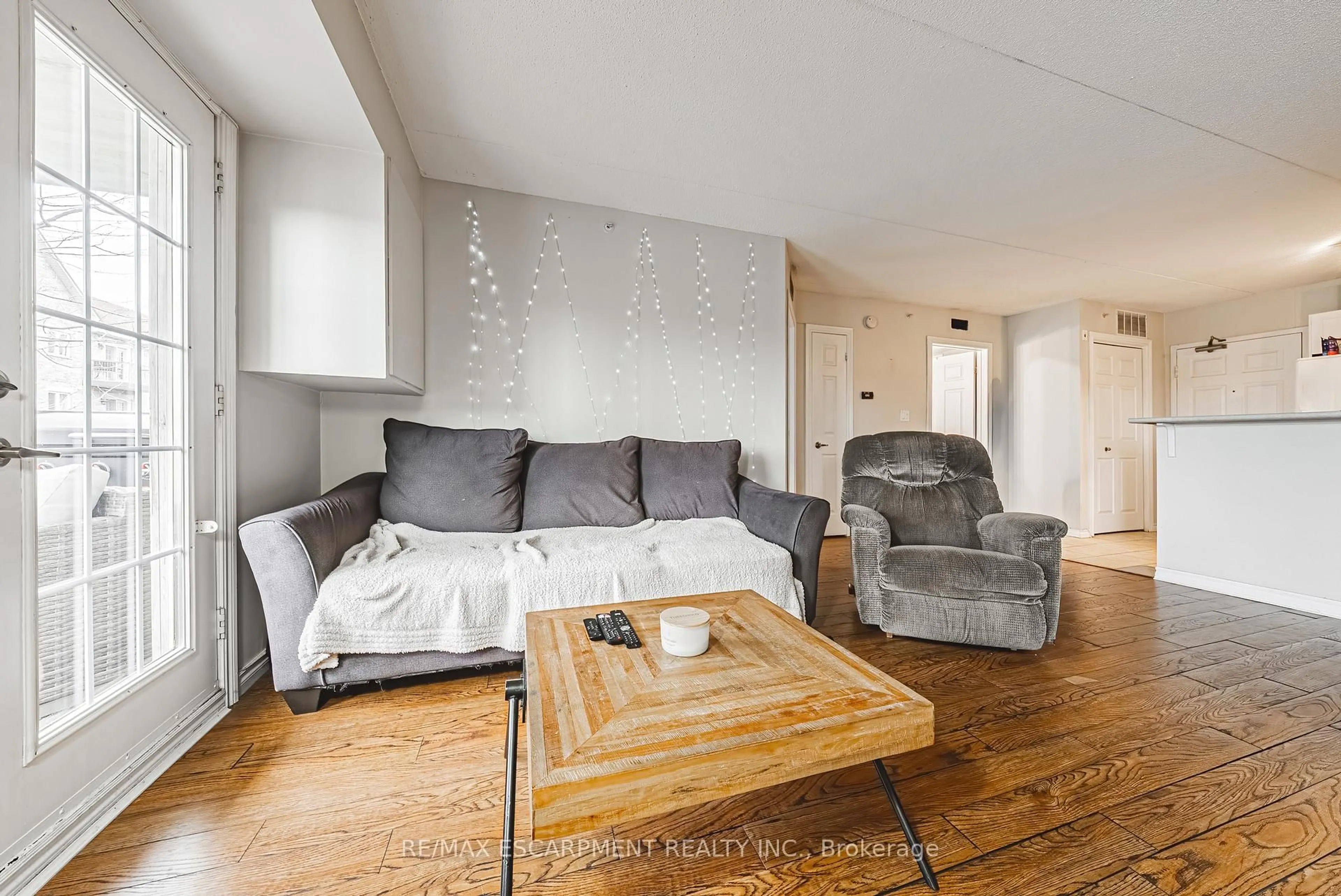 Living room with furniture, wood/laminate floor for 1451 Walkers Line #313, Burlington Ontario L7M 4P1