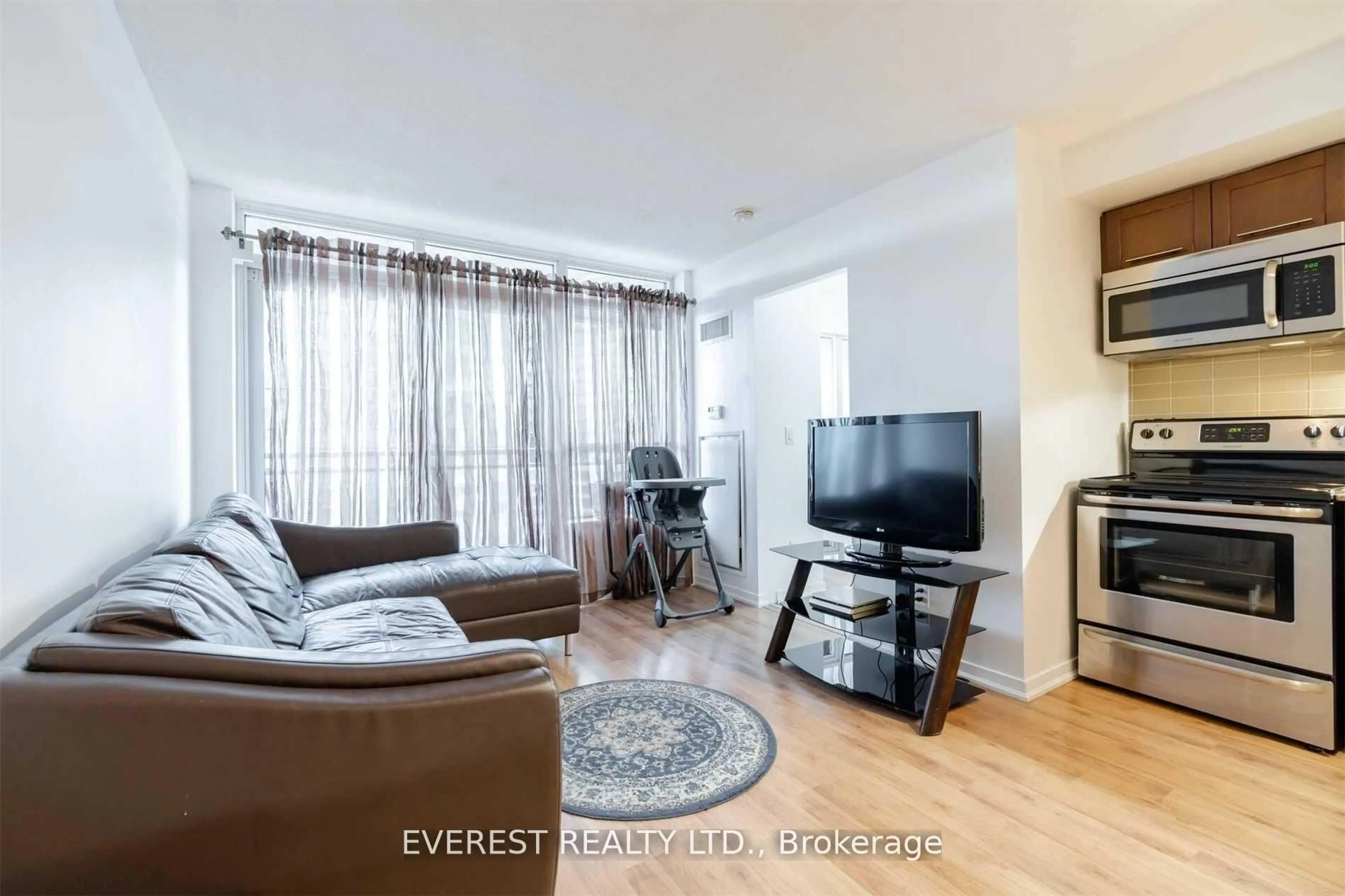 Living room with furniture, wood/laminate floor for 38 Joe Shuster Way #1025, Toronto Ontario M6K 0A5
