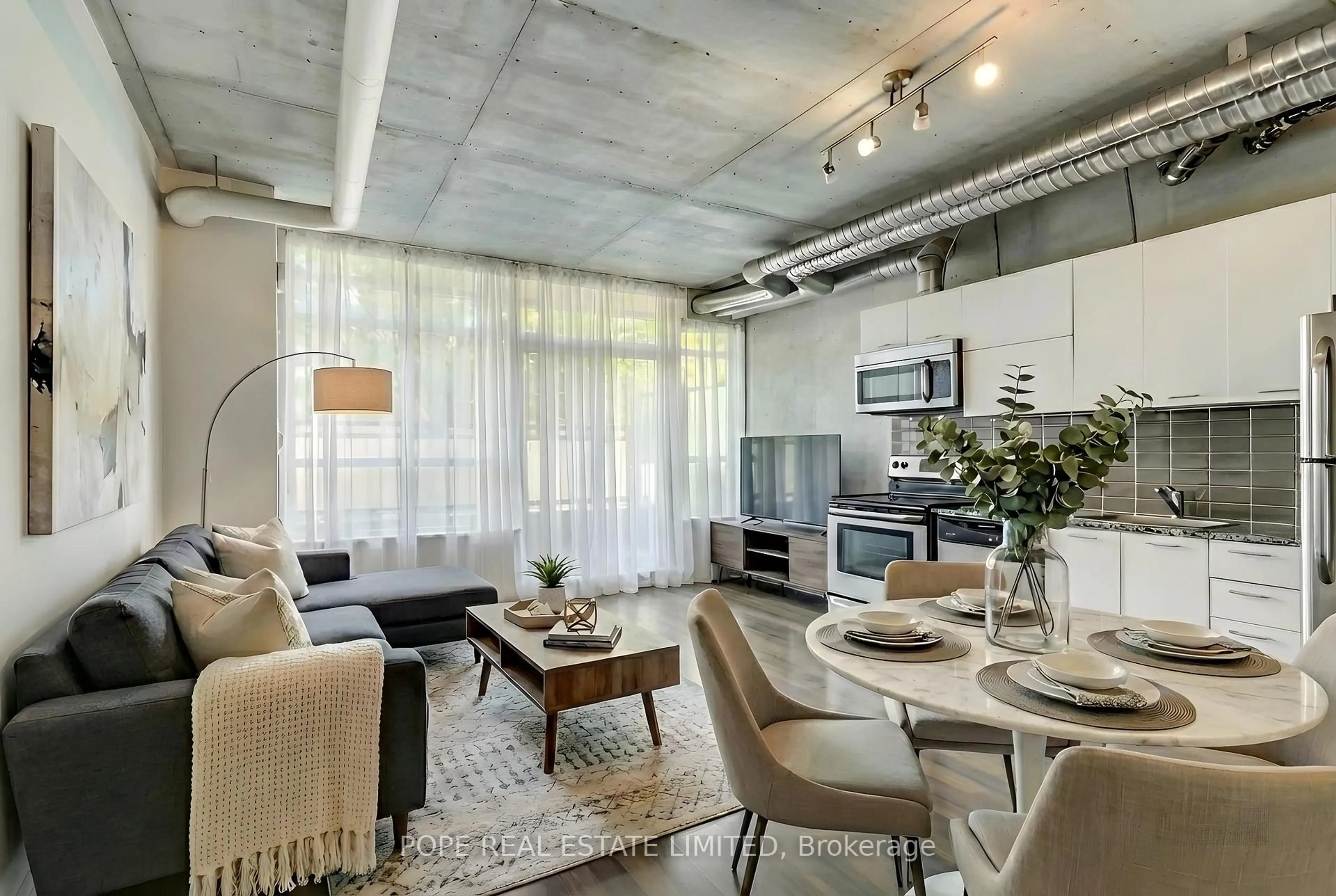 Open concept kitchen, cement floor for 38 Joe Shuster Way #312, Toronto Ontario M6K 0A5