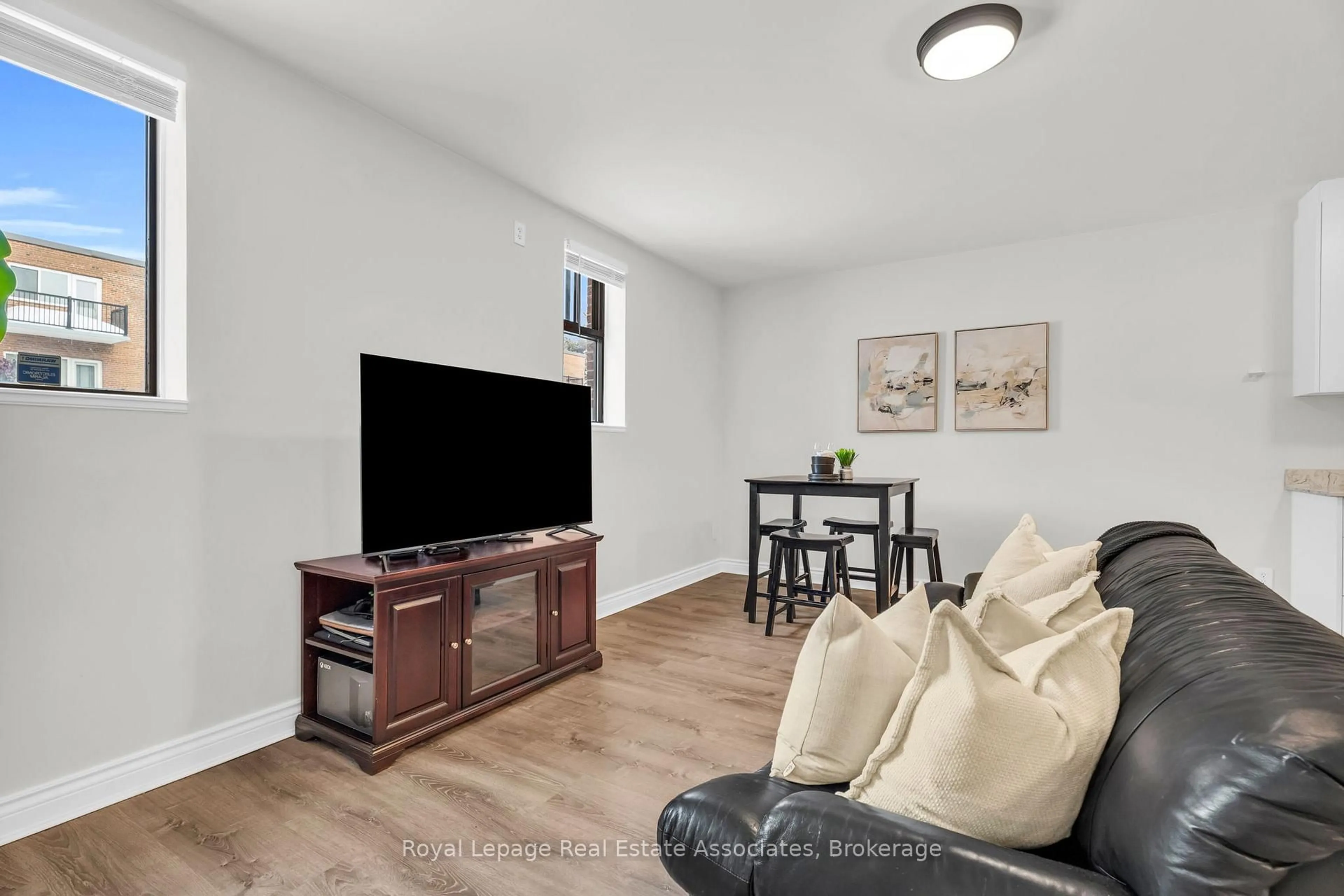 Living room with furniture, wood/laminate floor for 70 First St #102, Orangeville Ontario L9W 2E5