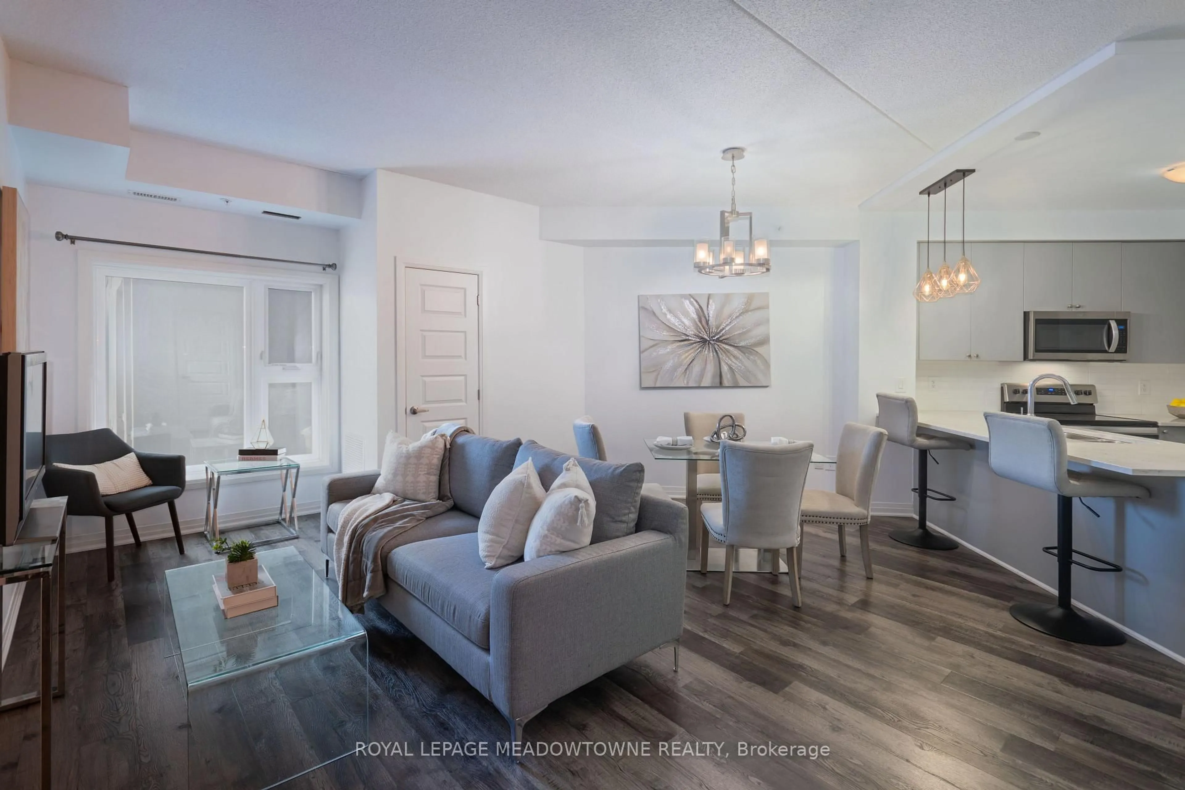 Living room with furniture, wood/laminate floor for 610 Farmstead Dr #324, Milton Ontario L9T 8X5