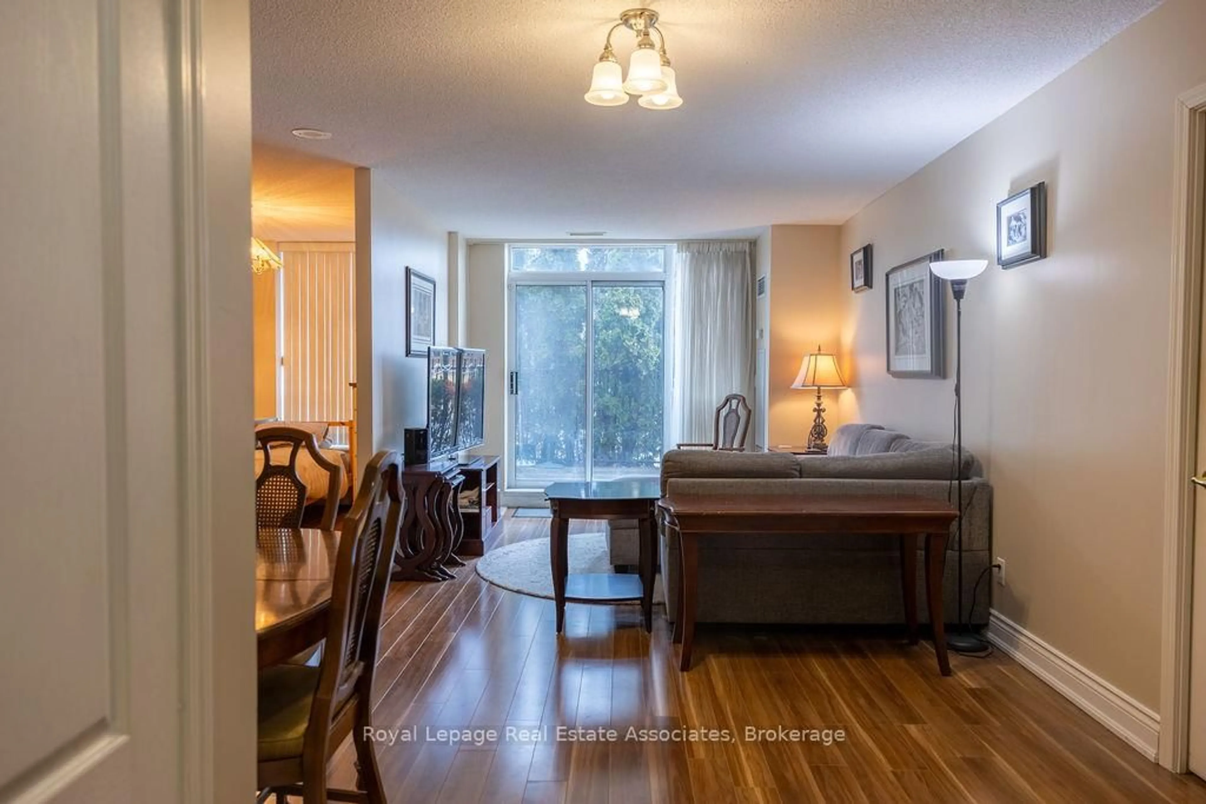Living room with furniture, wood/laminate floor for 1150 Parkwest Pl #104, Mississauga Ontario L5E 3K4