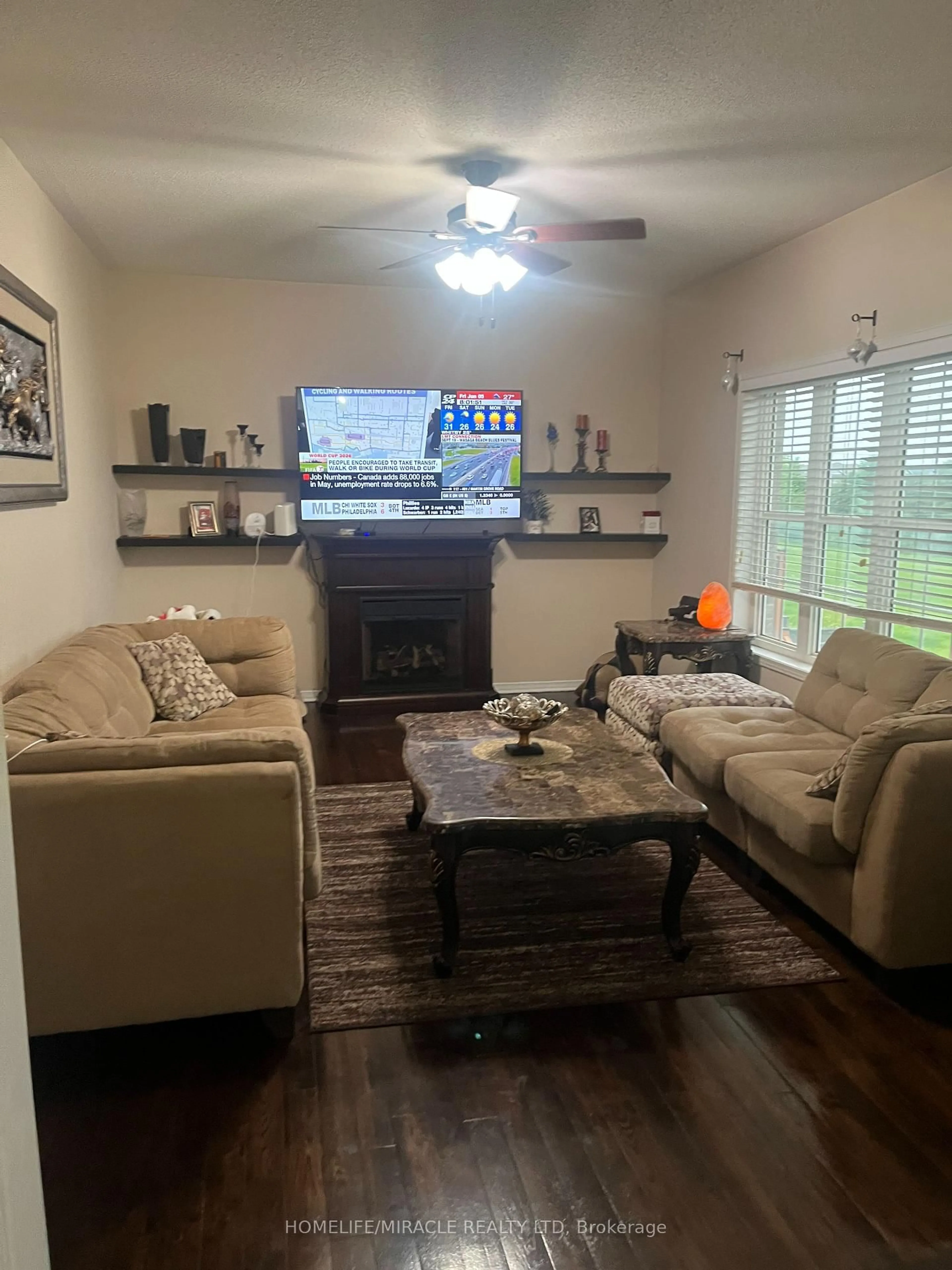 Living room with furniture, wood/laminate floor for 23 Roundstone Dr, Brampton Ontario L6X 0K7
