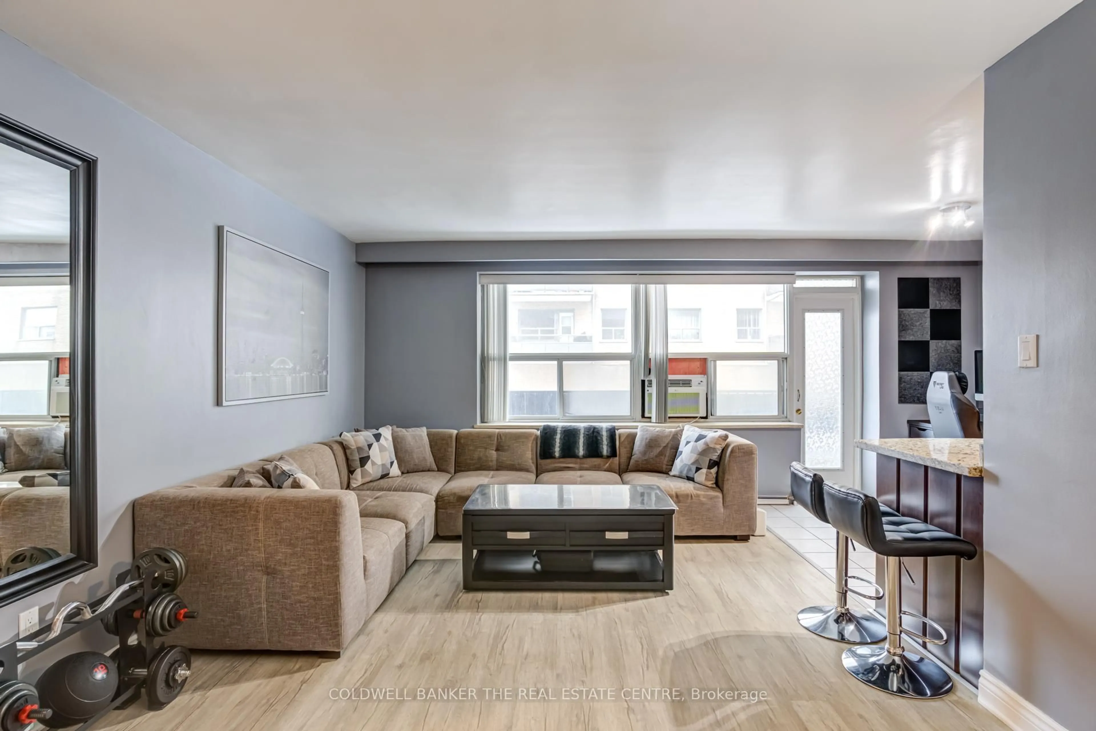 Living room with furniture, wood/laminate floor for 50 Gulliver Rd #208, Toronto Ontario M6M 2N2