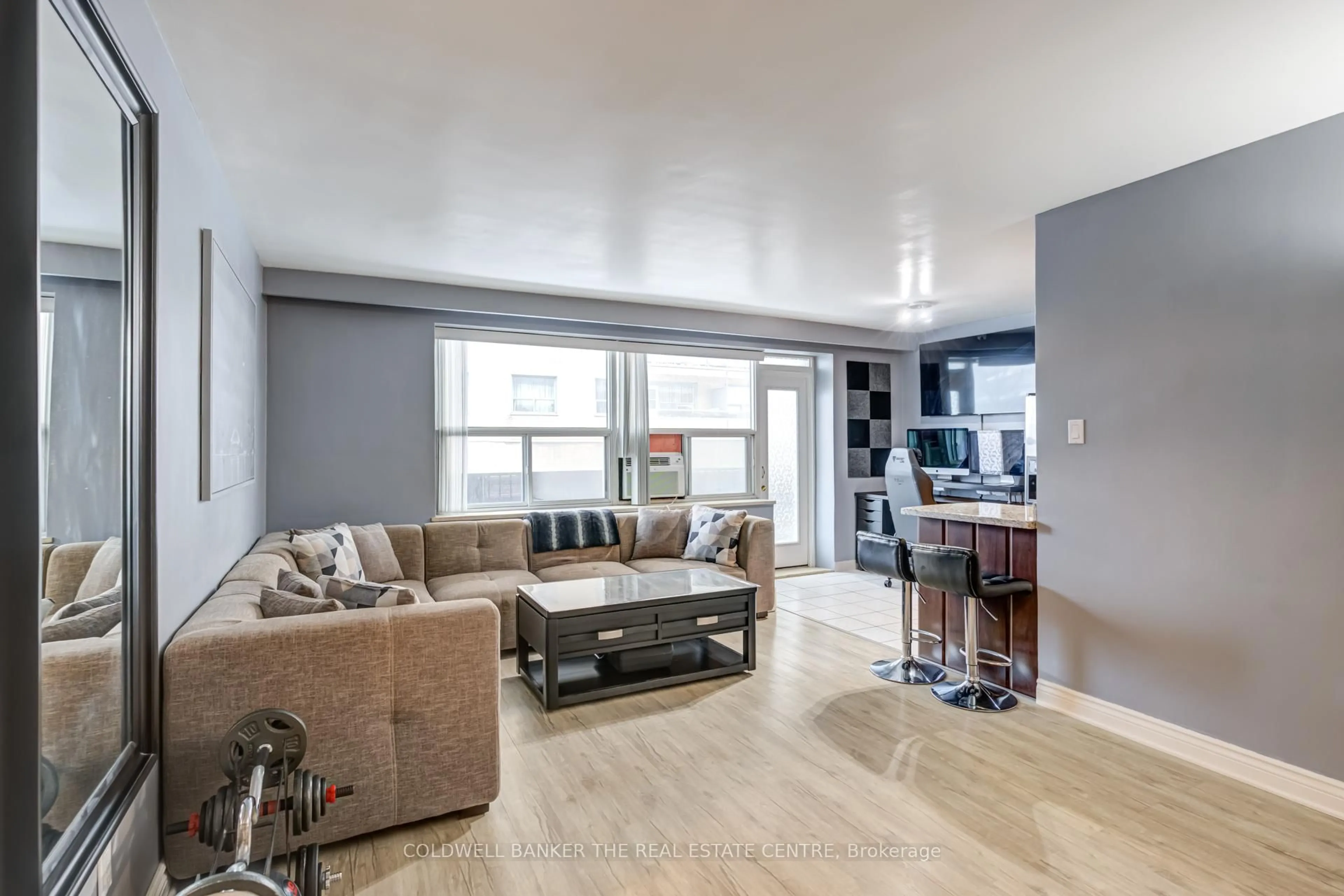 Living room with furniture, wood/laminate floor for 50 Gulliver Rd #208, Toronto Ontario M6M 2N2