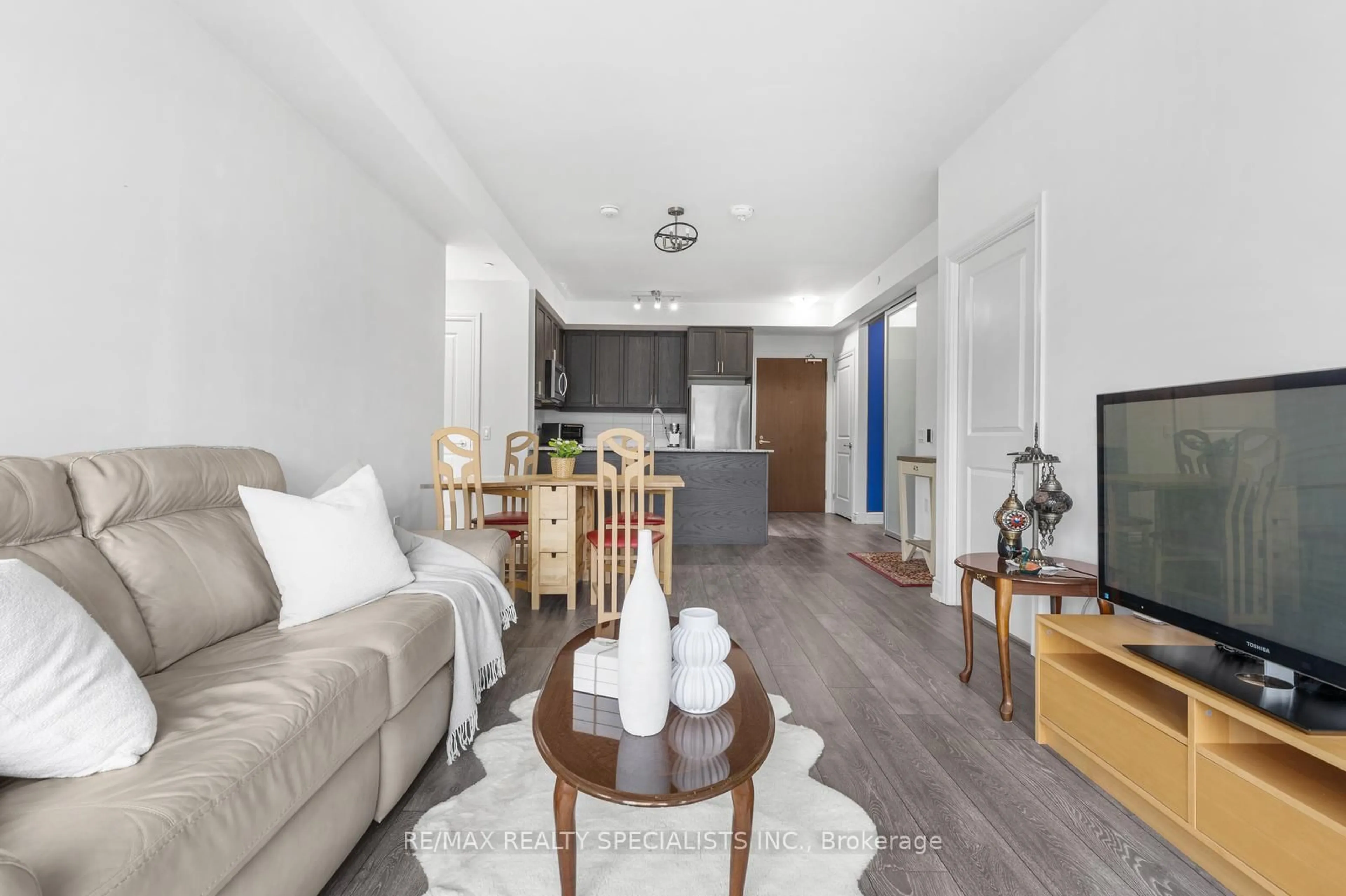 Living room with furniture, wood/laminate floor for 1050 Main St #226, Milton Ontario L9T 9M3