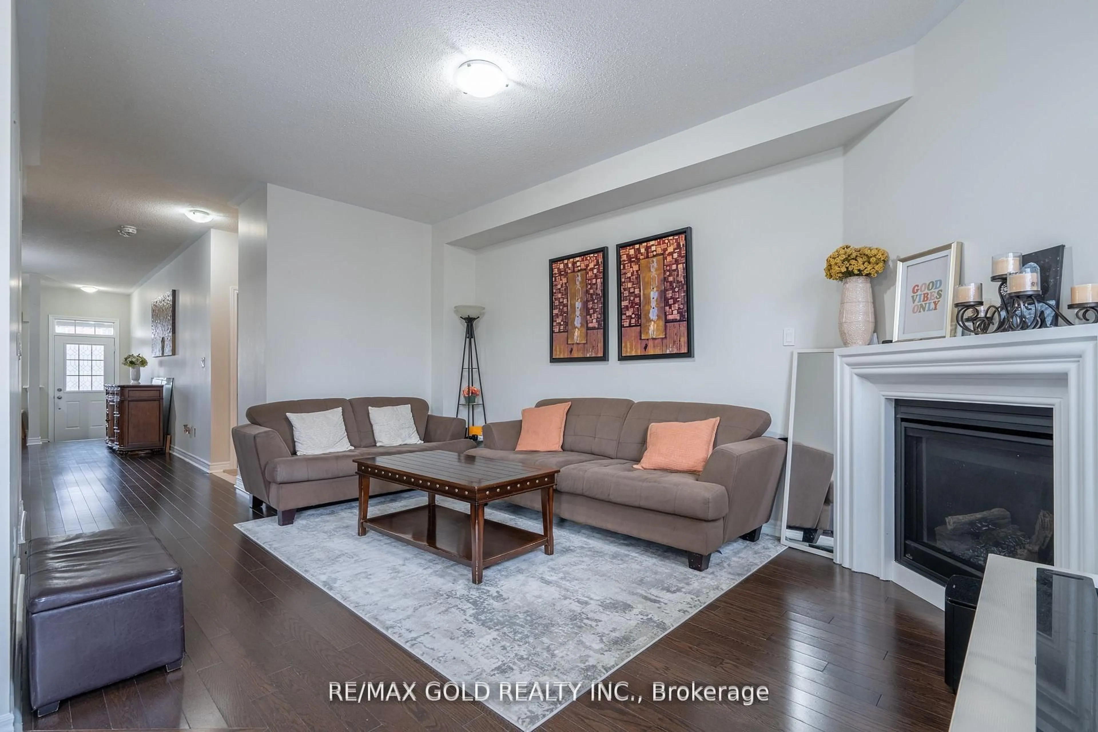 Living room with furniture, wood/laminate floor for 65 Villadowns Tr, Brampton Ontario L6R 3Y8